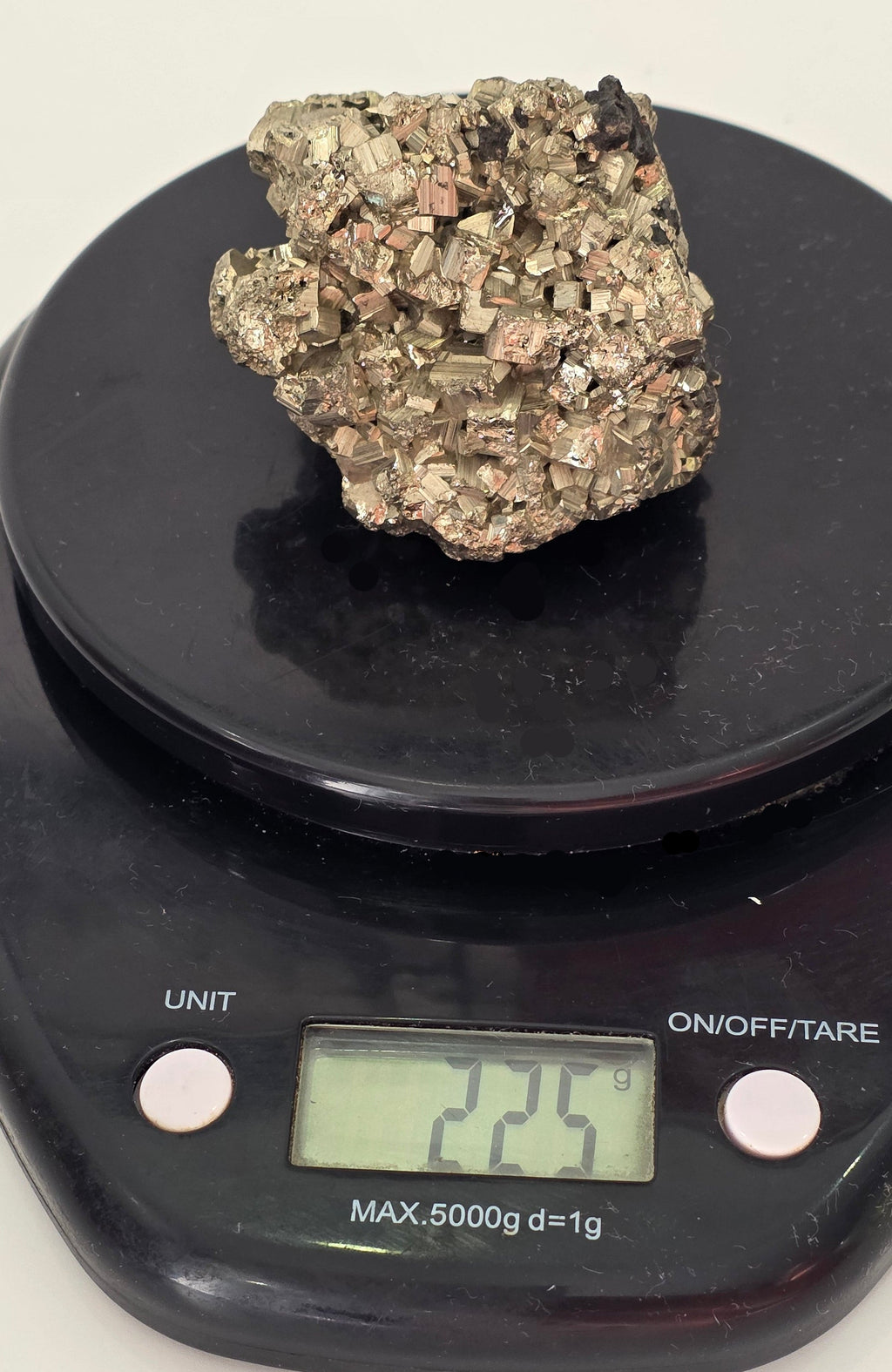 Natural pyrite chispa cluster weighing 225 grams showing metallic gold-silver cubic crystal formations on weighting scales