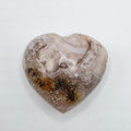 Heart-shaped stone with a rough texture on a white background