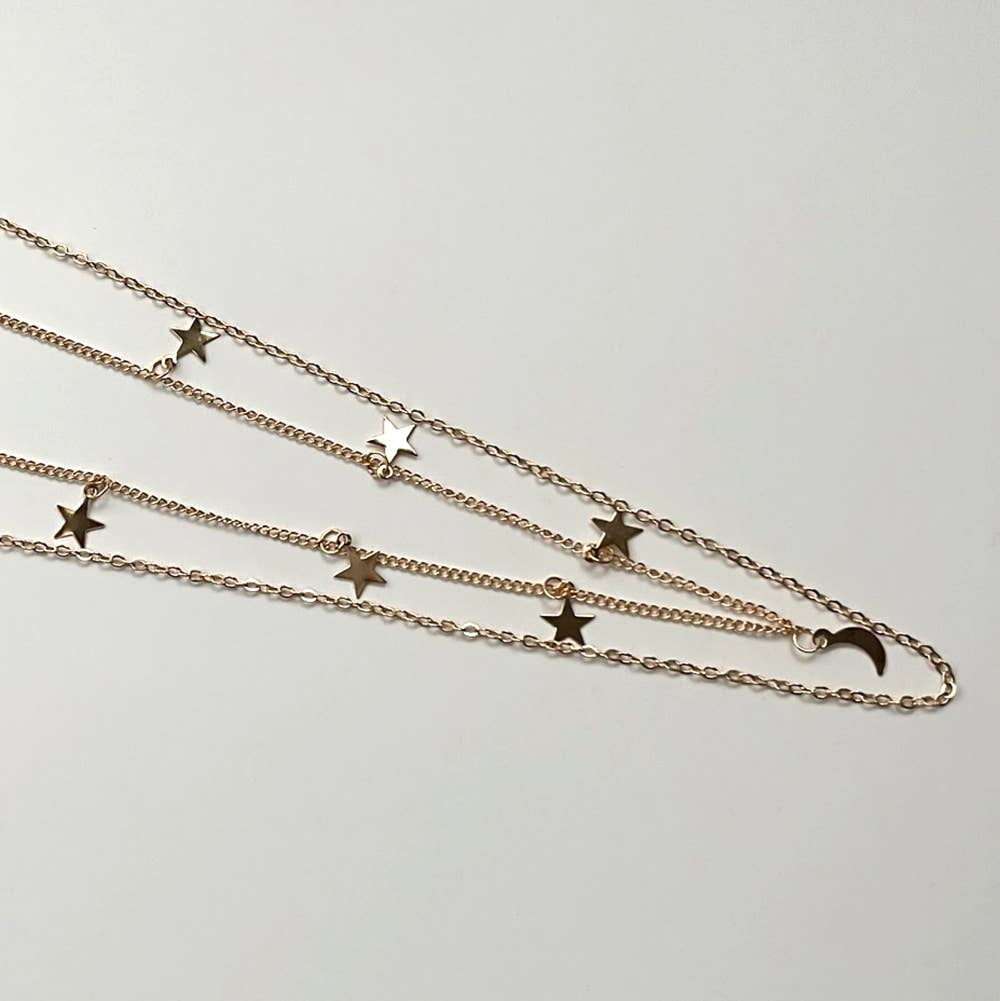 Two chain gold necklaces with star and moon pendants on a white background