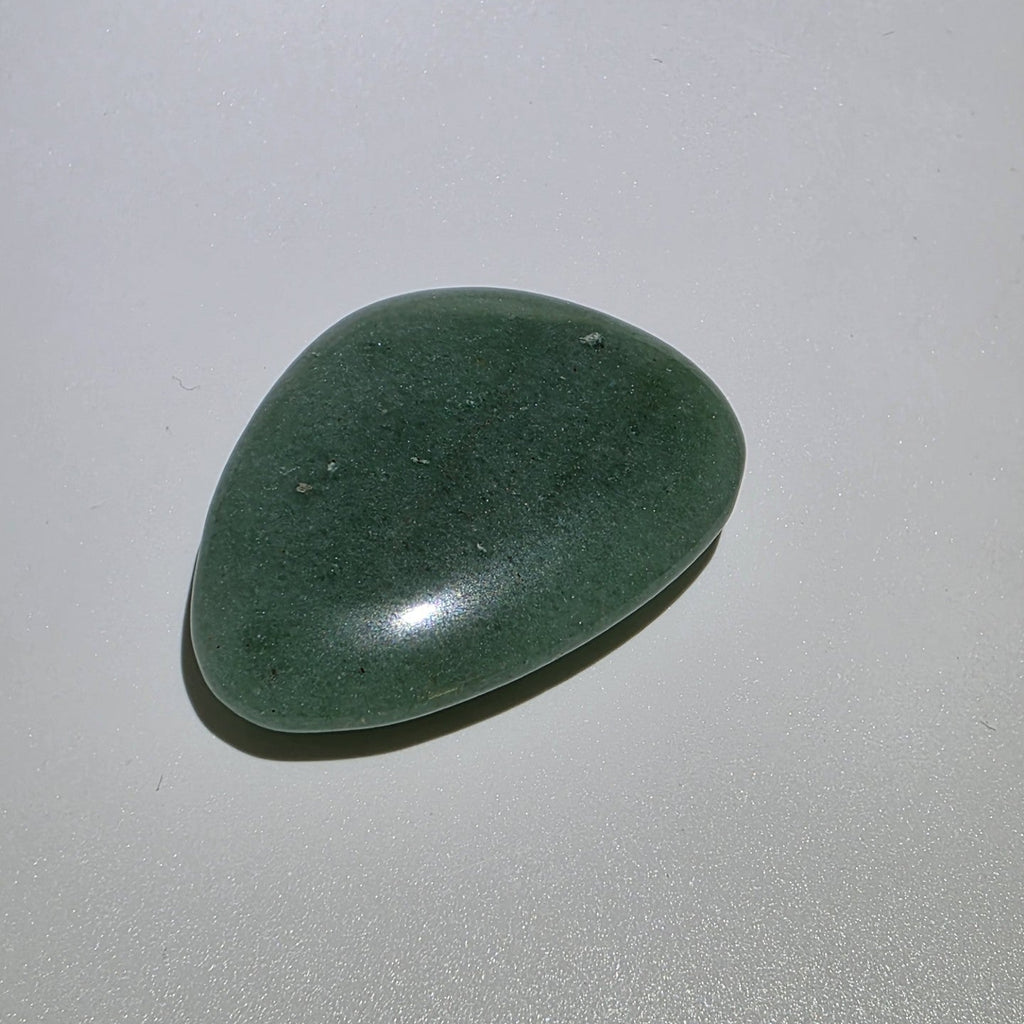 Green aveturine palm stone on a white background 