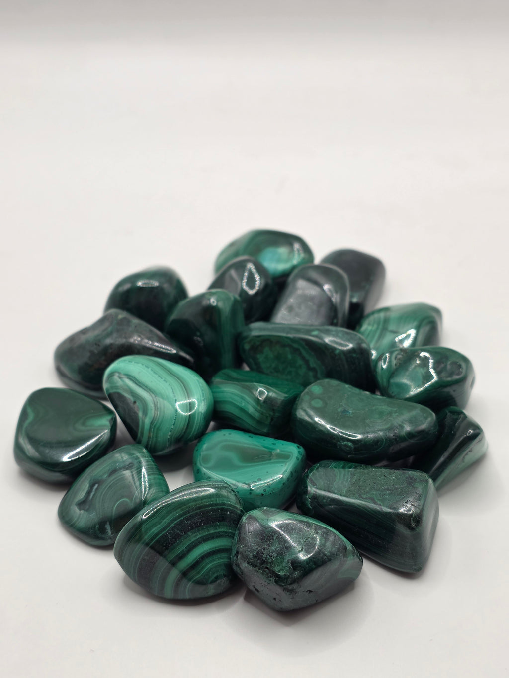 Collection of green malachite stones on a white background