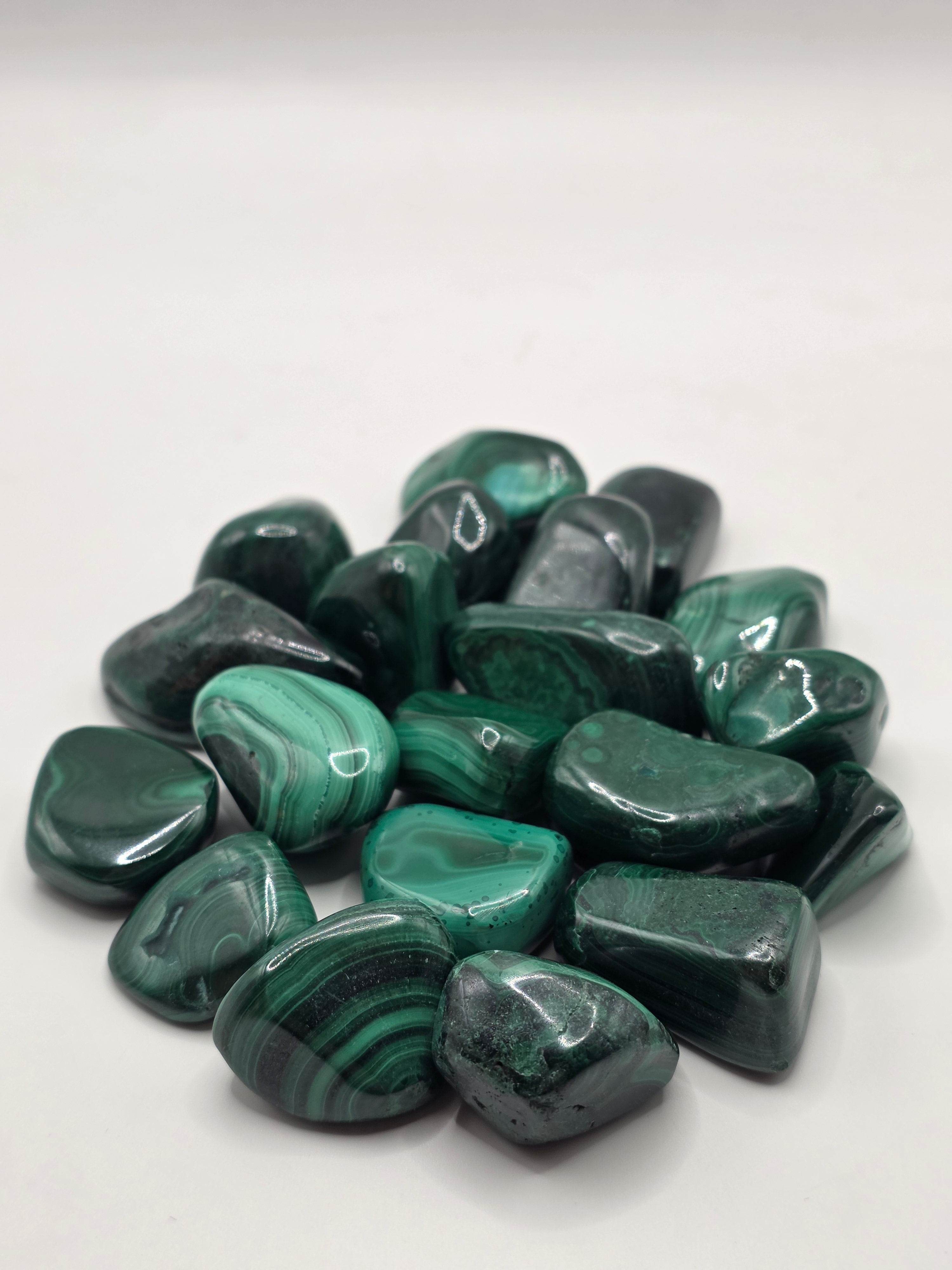 Collection of green malachite stones on a white background