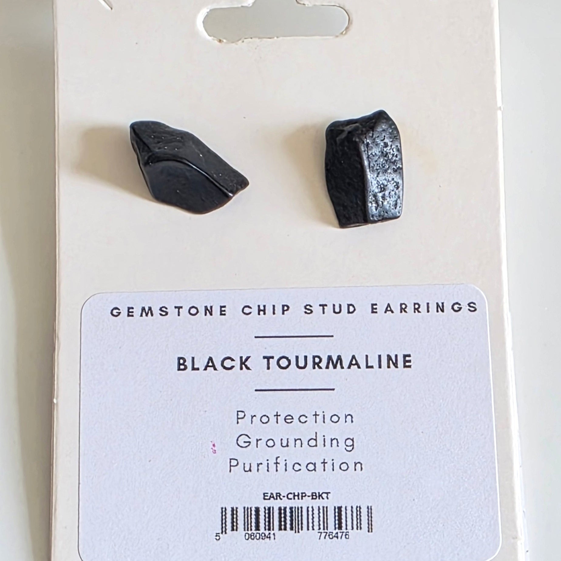 Black tourmaline earrings on a white card with text on a white background