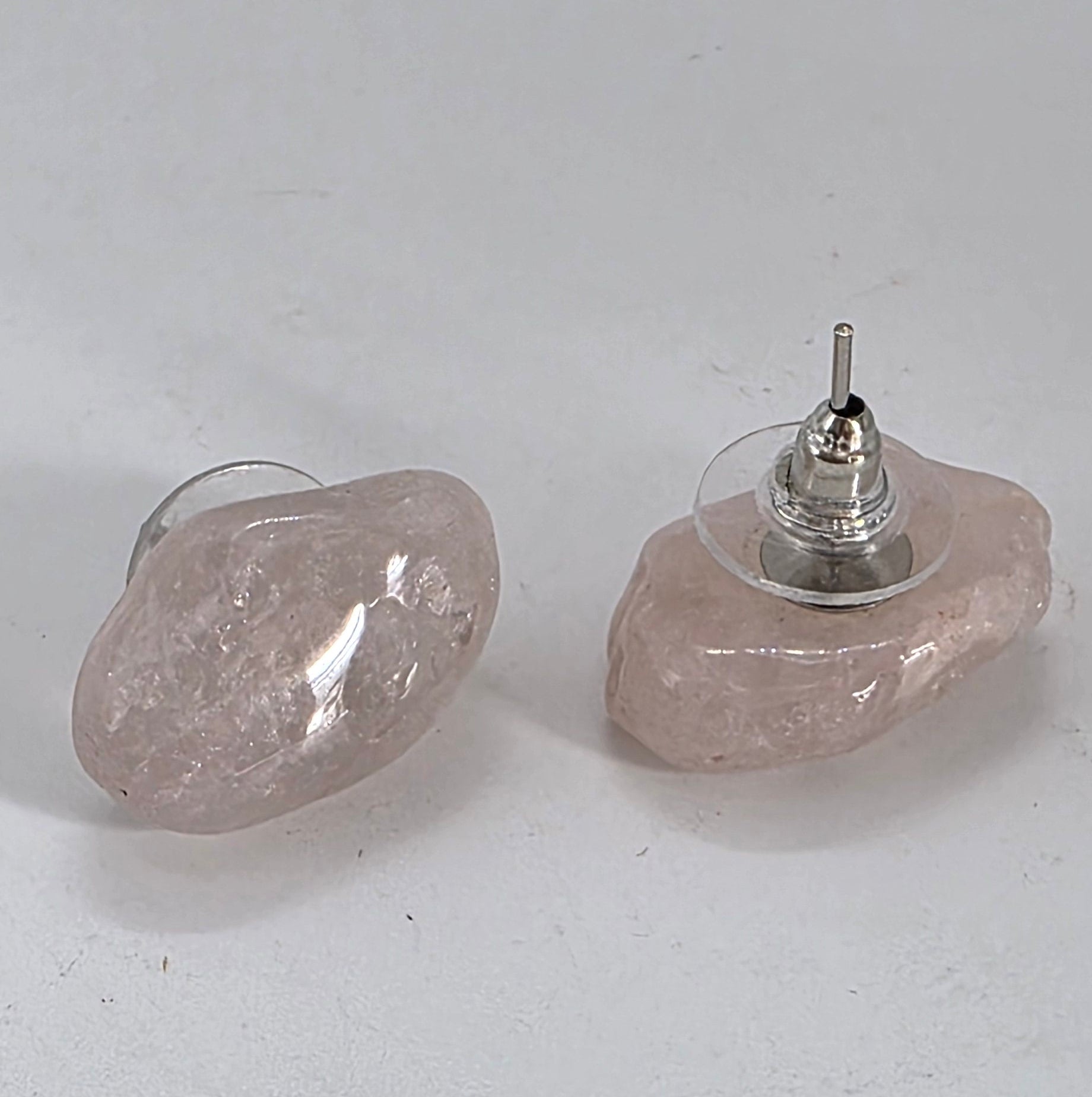 Pair of earrings with rose quartz and silver base on a white background