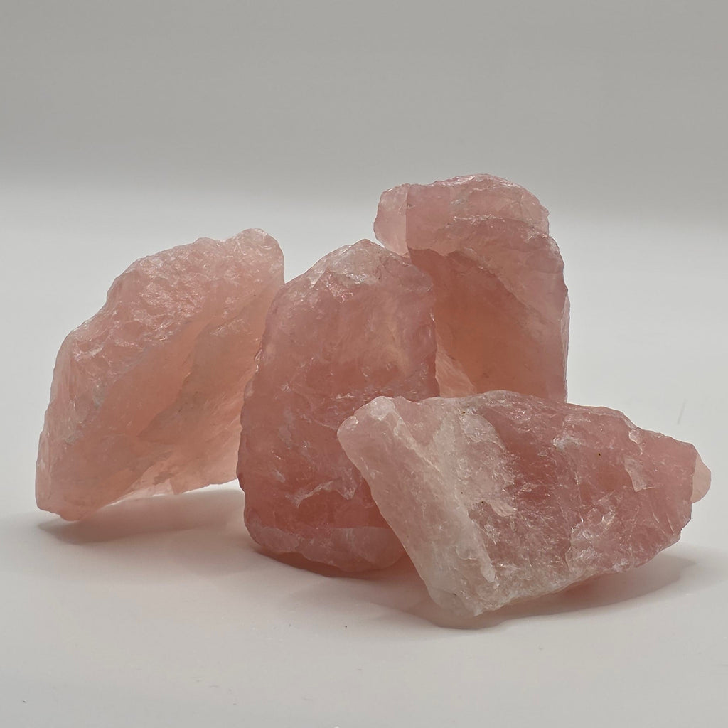 An image of 4 raw rose Quartz Crystals arranged in a cluster