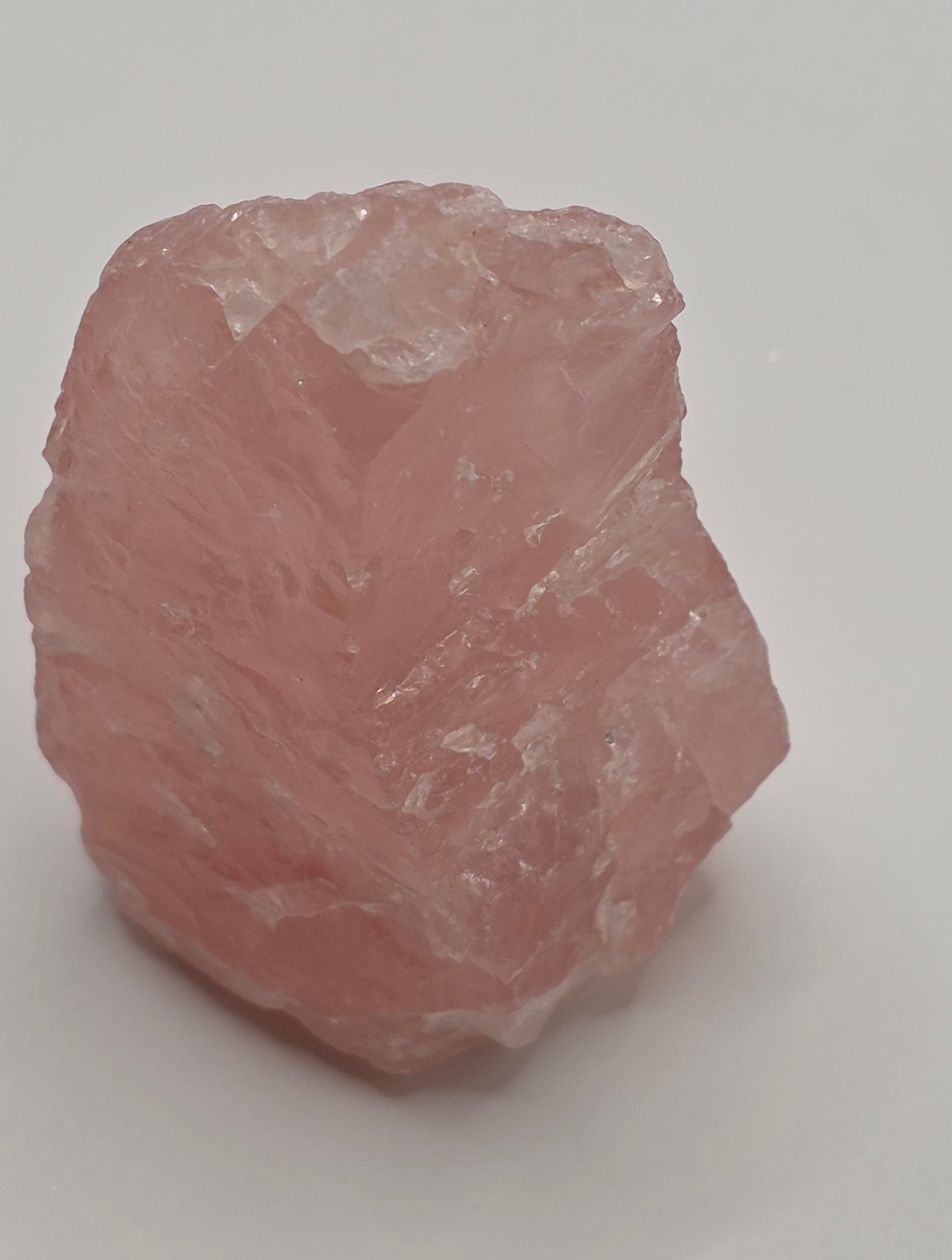 Raw rose quartz crystal side view showing all its beautiful imperfections. This is whats makes each and every raw crystal unique.
