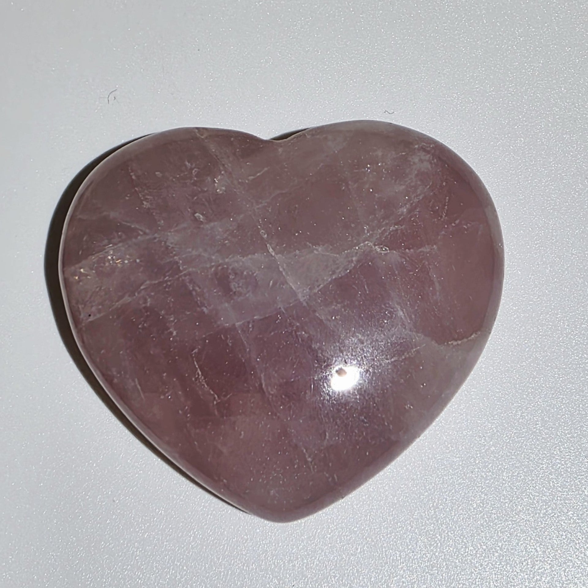 Heart-shaped Rose Quartz Crystal on white background