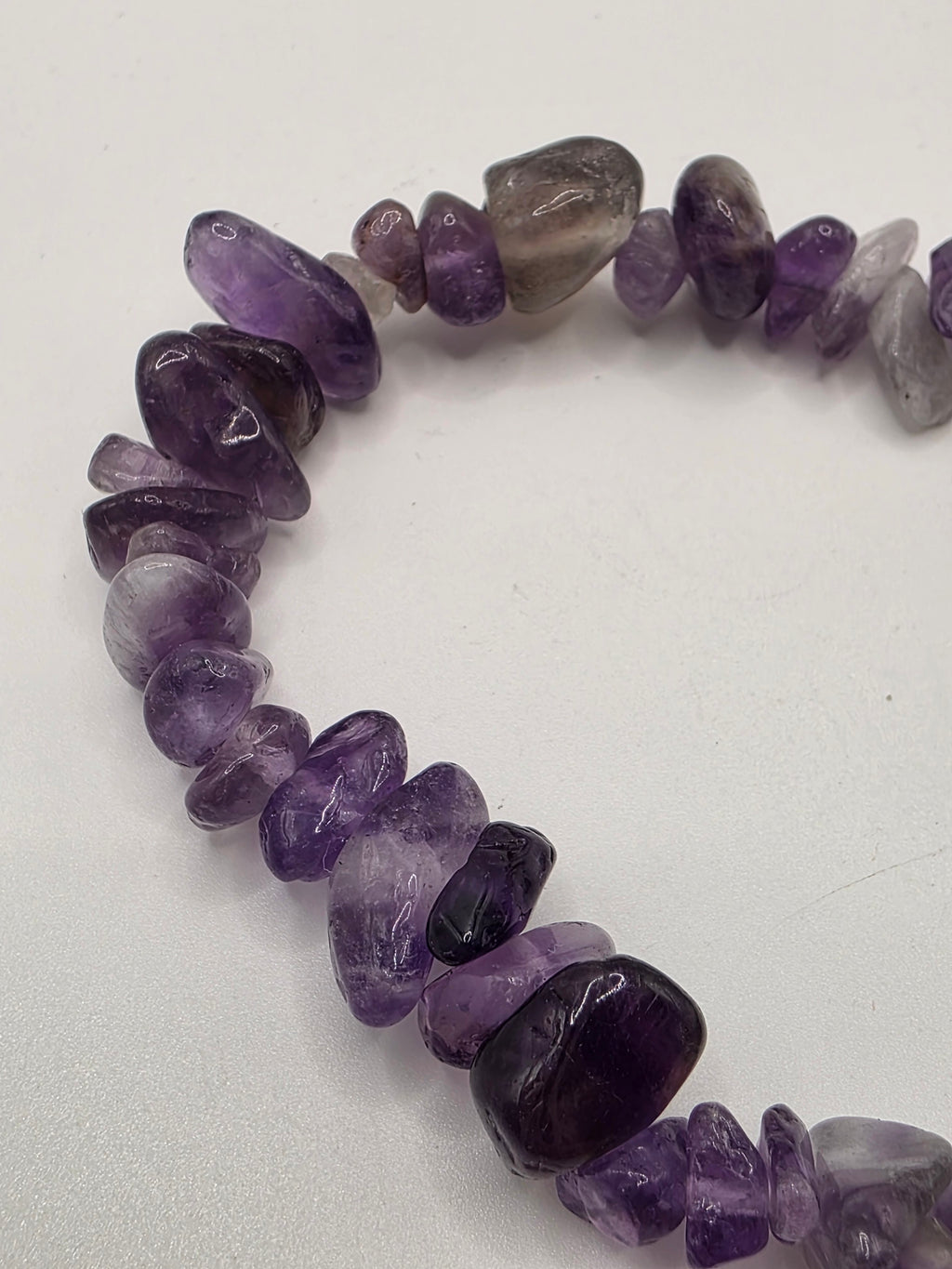 Close up of amethyst chips showing purple colour and natural stone variations – pale lavender to deep violet