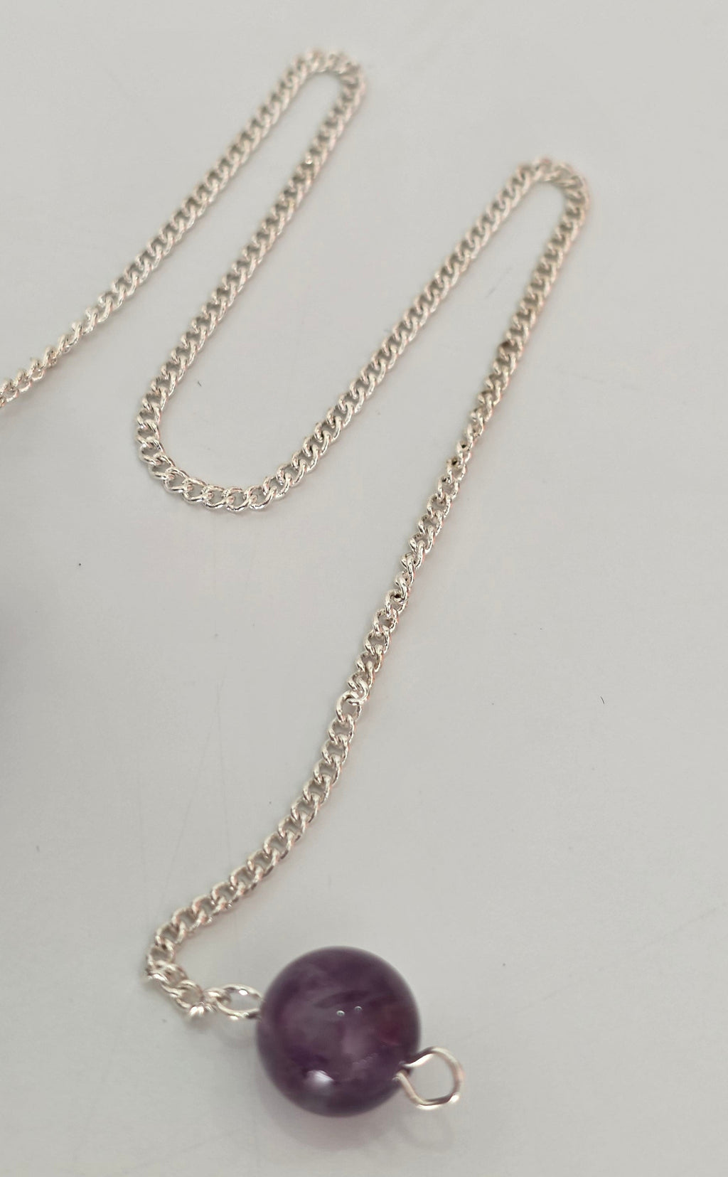 Close up of silver plated pendulum chain and clasp showing metal finish