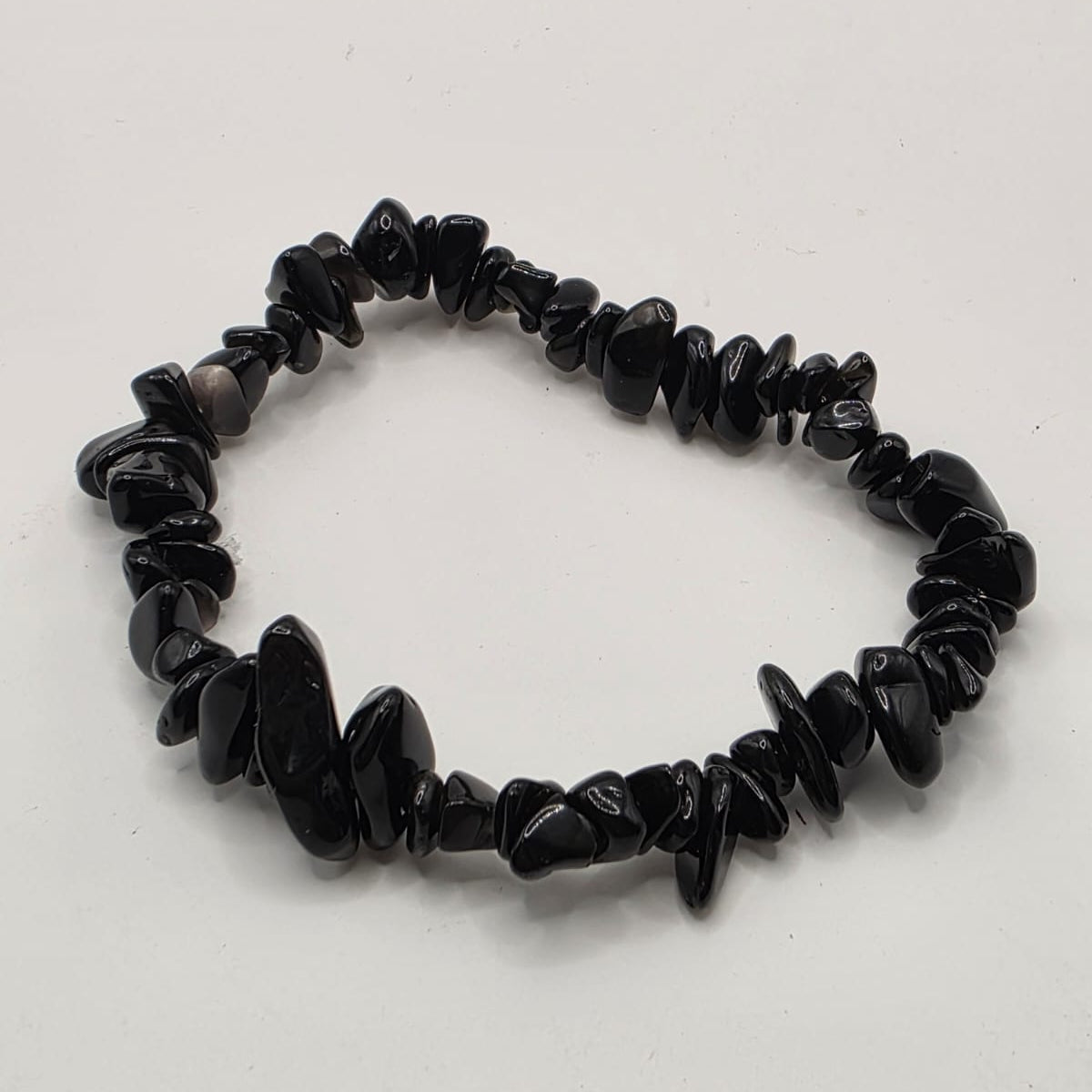 Black obsidian chip bracelet on white background – natural volcanic glass chips for protection and grounding