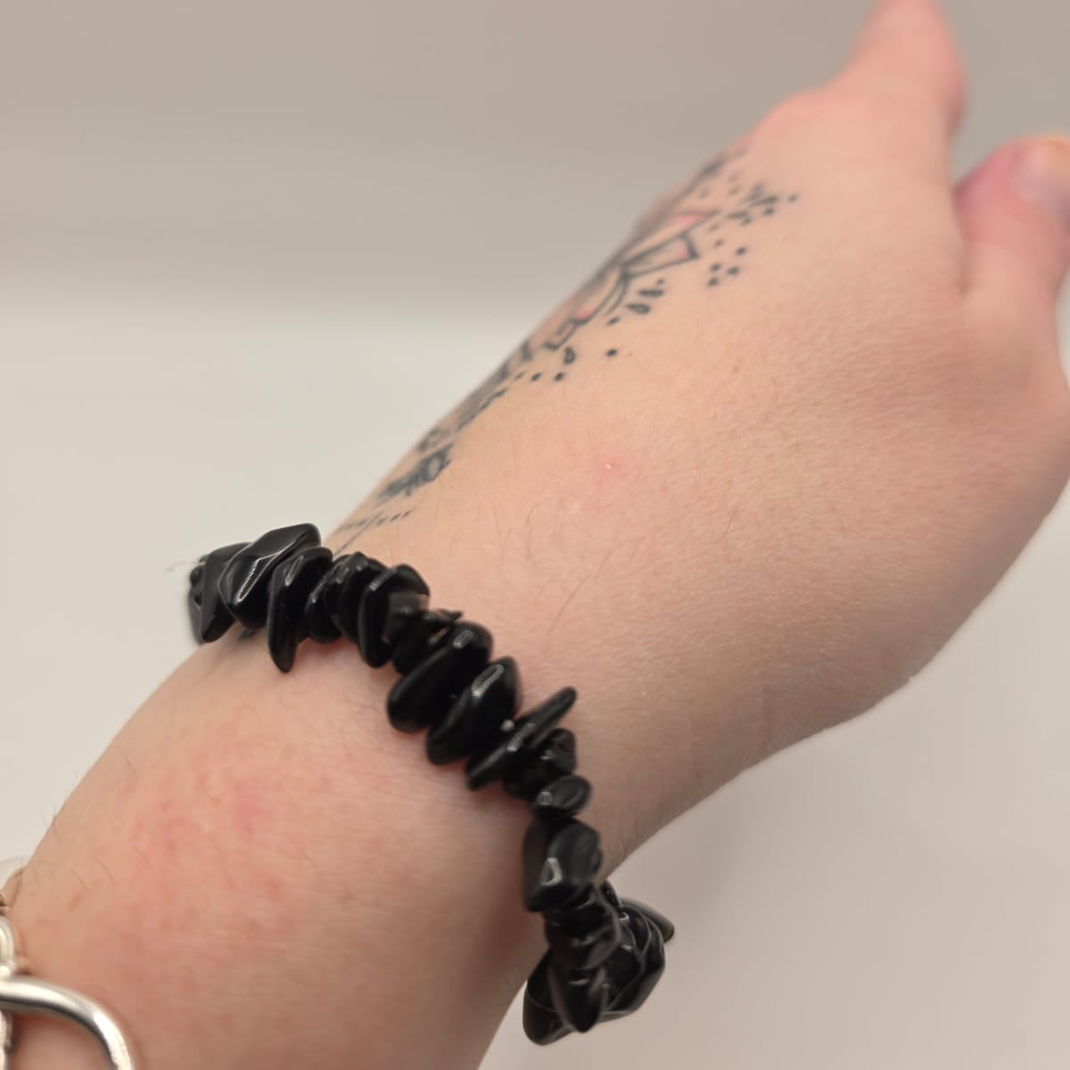 Black obsidian chip bracelet worn on a wrist – double strung elastic stretch bracelet for crystal healing on the go	