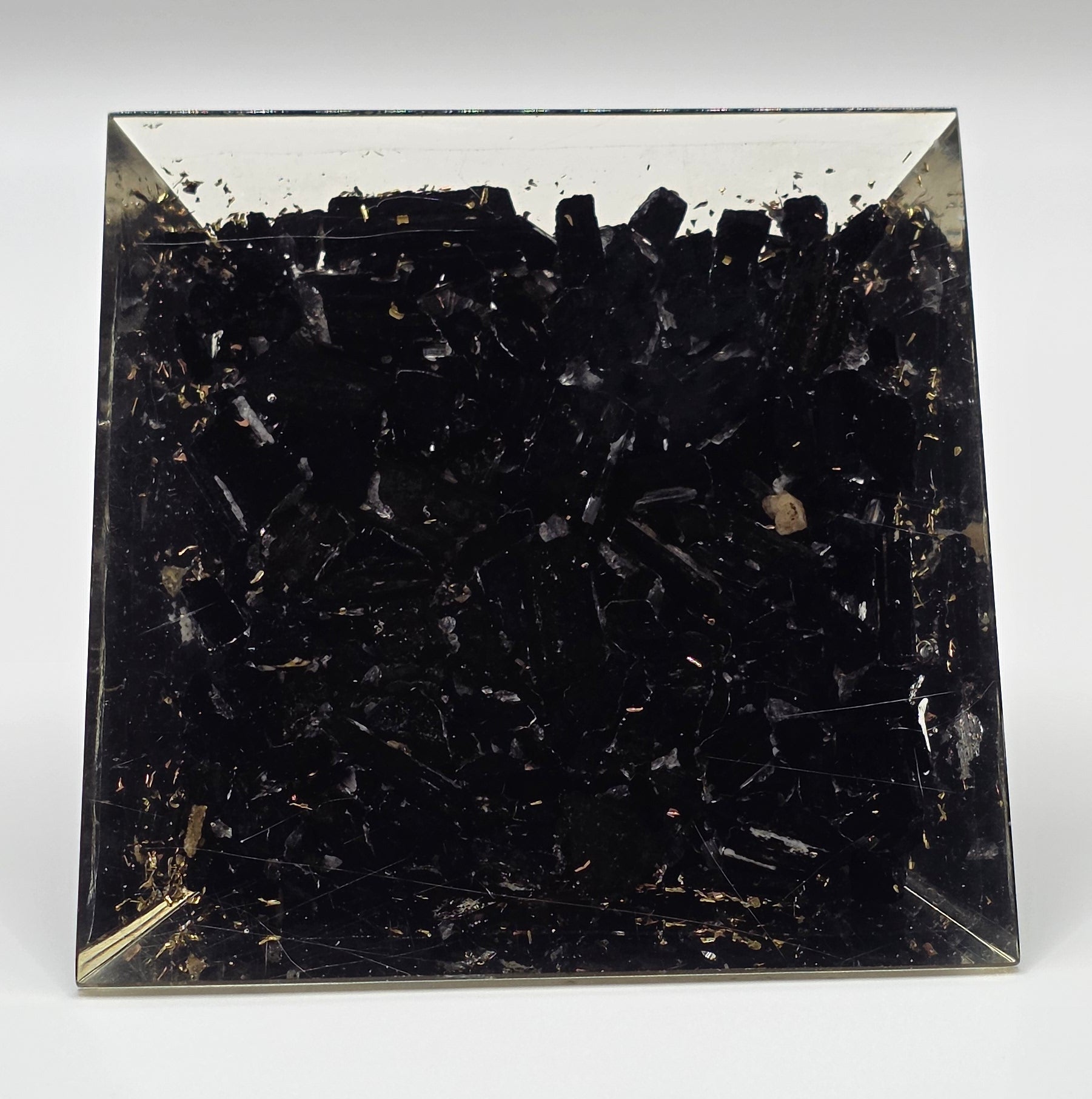 Base view of the Black tourmaline orgonite pyramid 60mm on white background – black crystal pyramid for protection and grounding