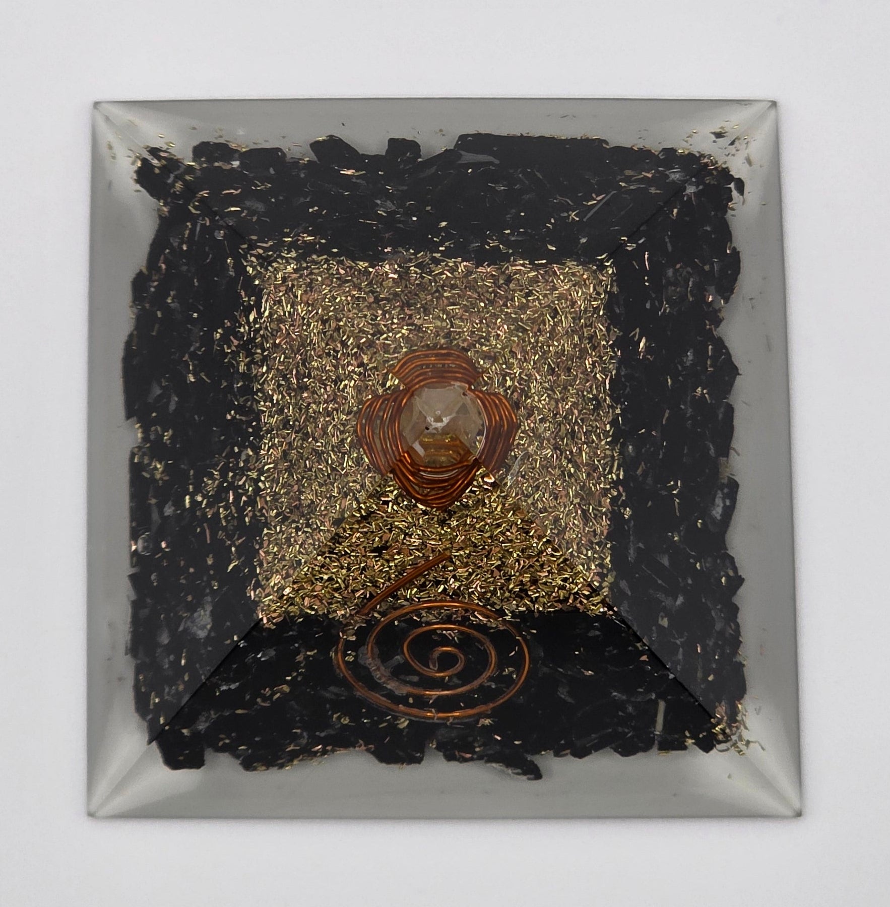 Birdseye view of a Black tourmaline orgonite pyramid 60mm on white background – black crystal pyramid for protection and grounding