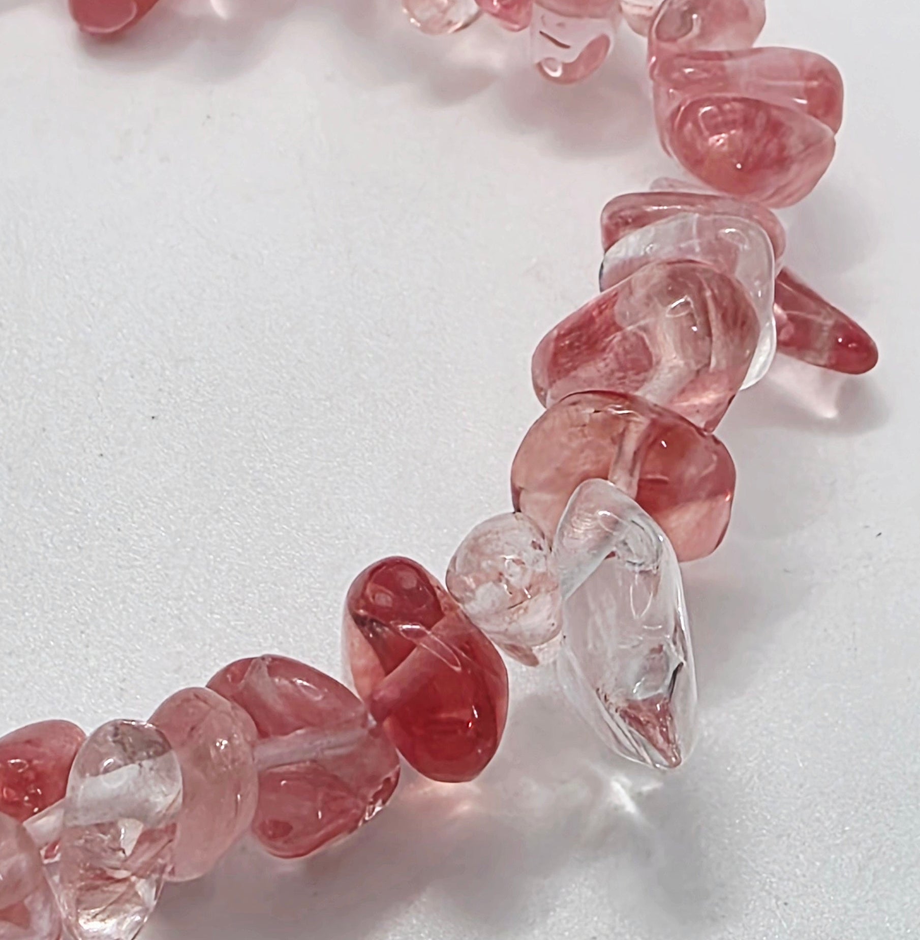 Close-up of cherry quartz chips showing translucent pink-red colour and natural variations