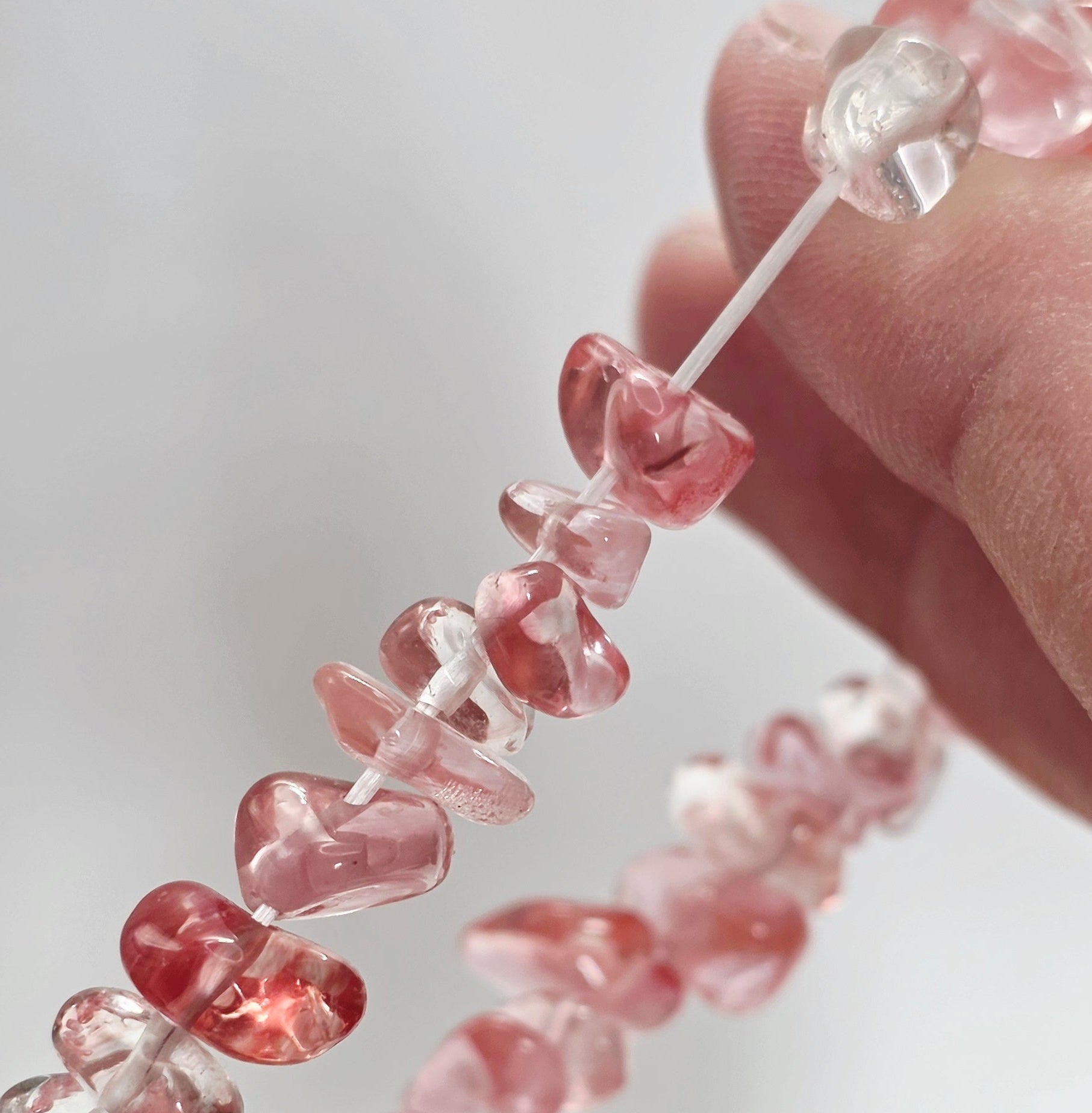 Close-up of cherry quartz chips showing translucent pink-red colour and natural variations