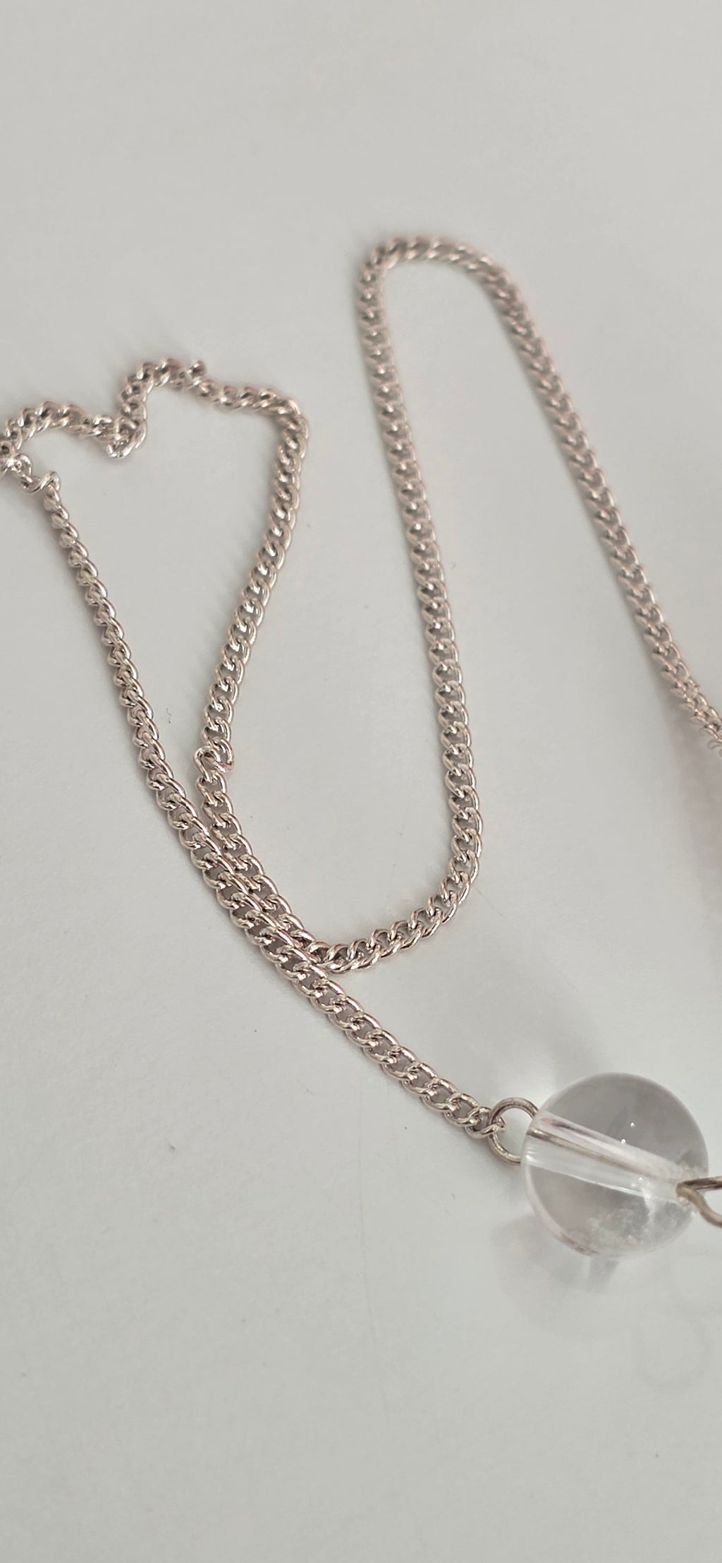 Close up of silver plated pendulum chain and clasp showing metal finish