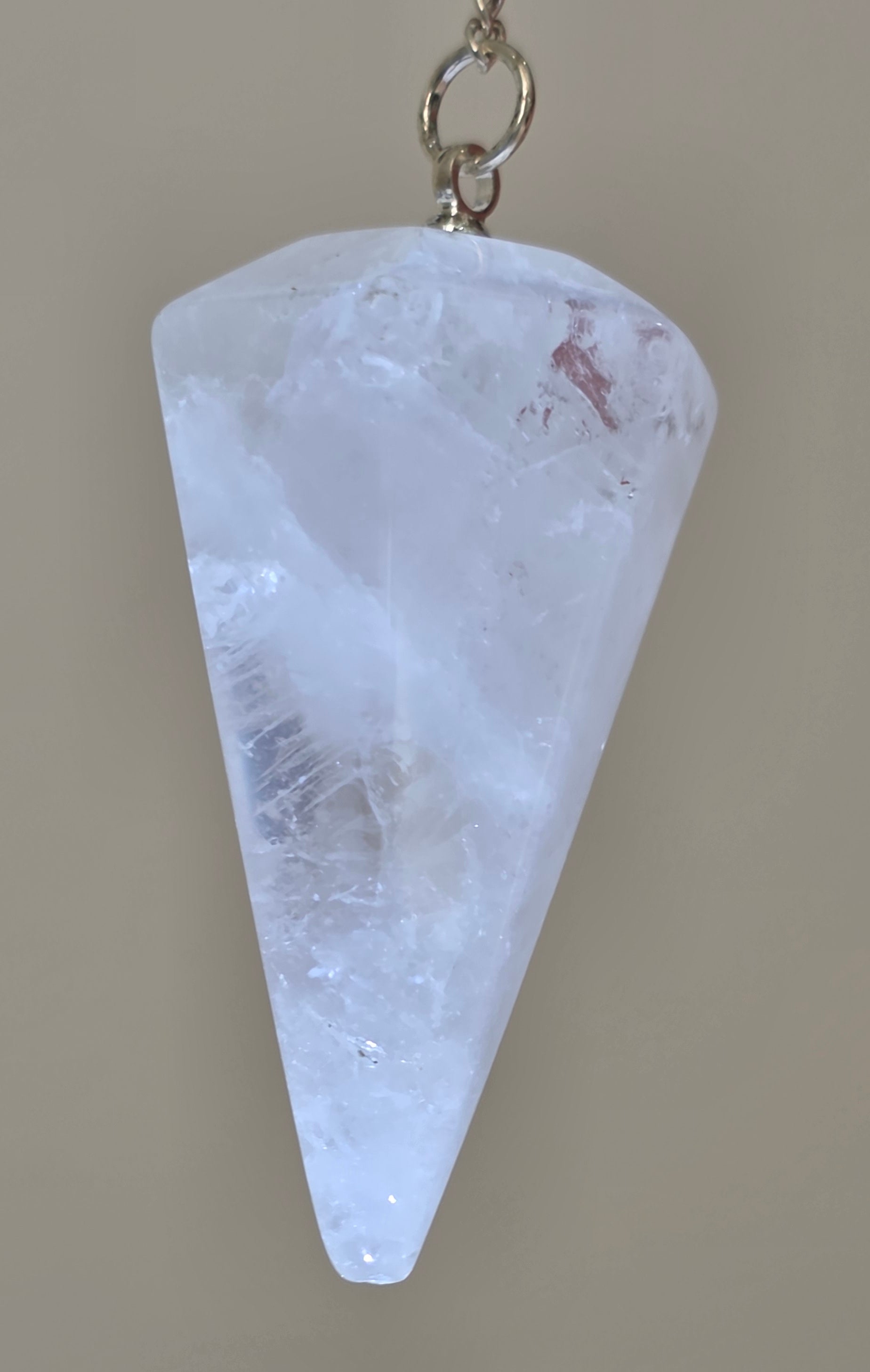 Close up of faceted clear quartz crystal point showing clarity and natural glow