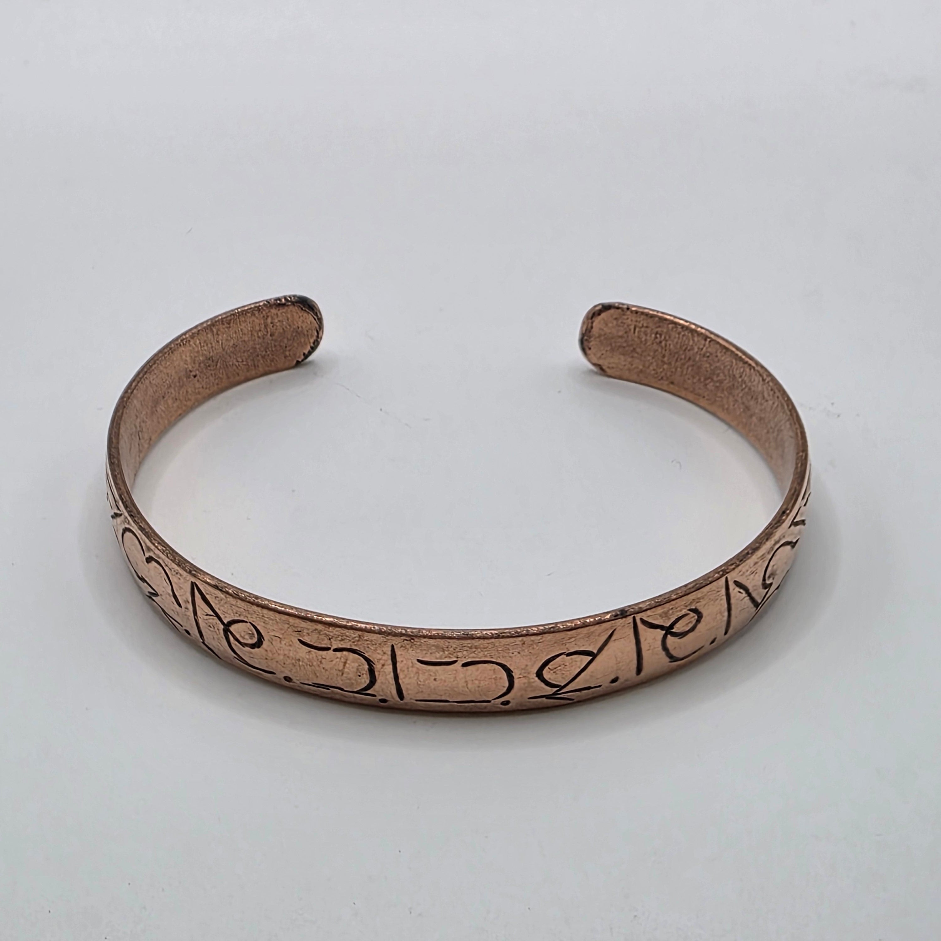 Hand etched copper cuff with om mani padme hum mantra – flat open oval shape on white background