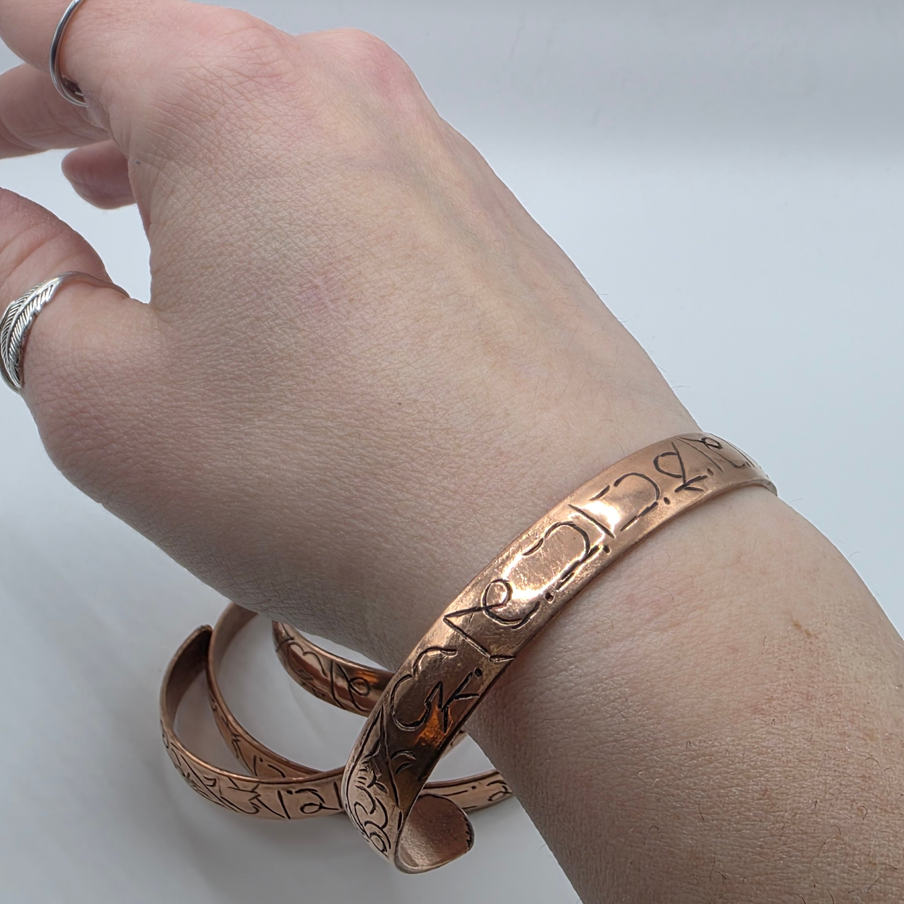 Adjustable copper cuff with buddhist mantra worn on a wrist – om mani padme hum etched copper bracelet