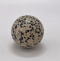 Dalmatian jasper crystal sphere 35mm on white background – polished black and white speckled stone for grounding and playfulness