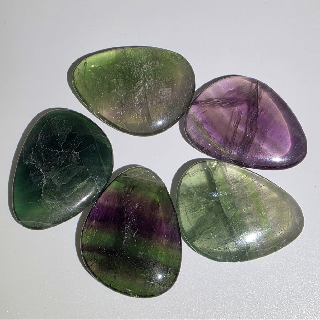 Five multicolored fluorite crystals on a white background
