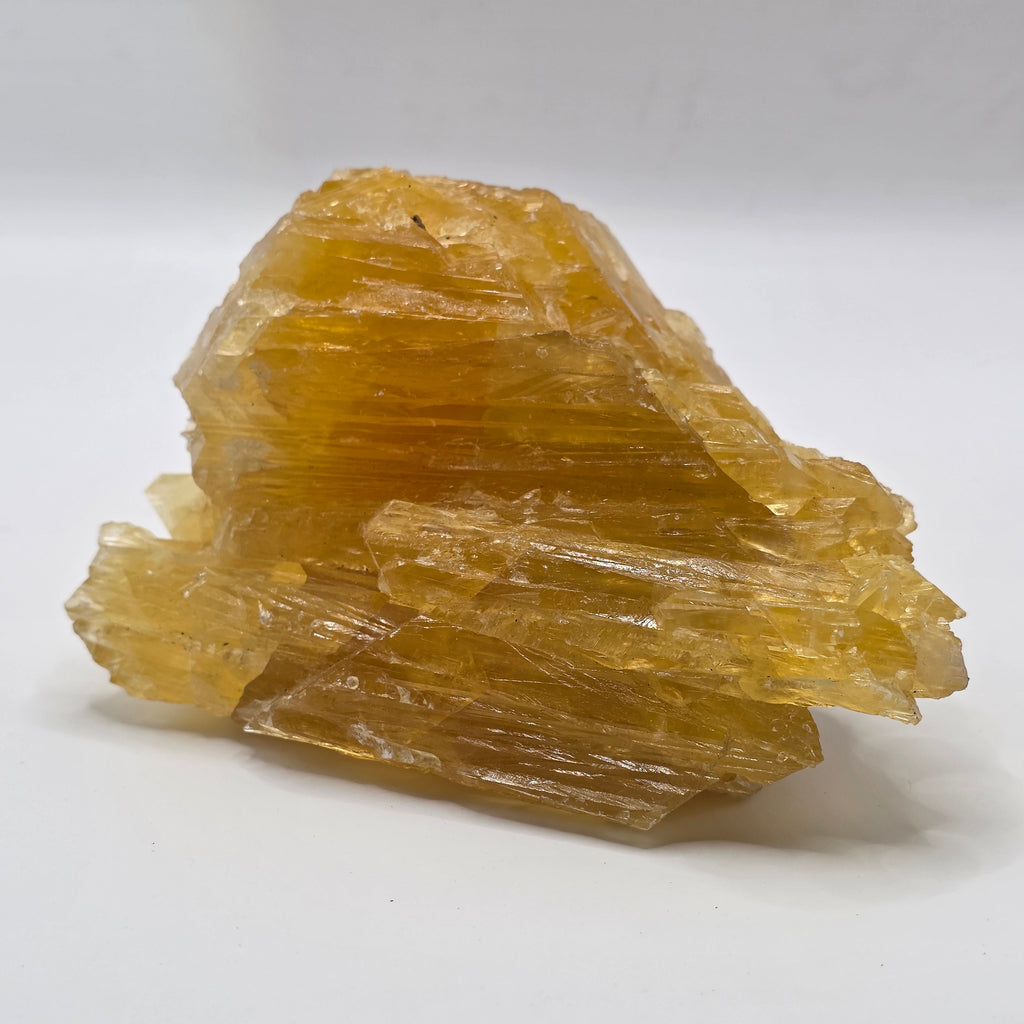Golden calcite 470g from Afghanistan on white background – natural golden-orange crystal for abundance and manifestation