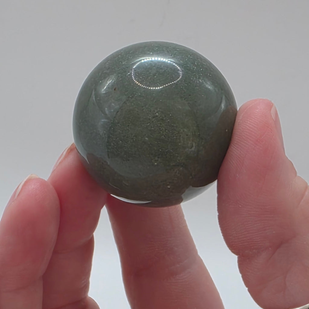 Close up of green aventurine sphere showing natural shimmer and sparkle – aventurescence