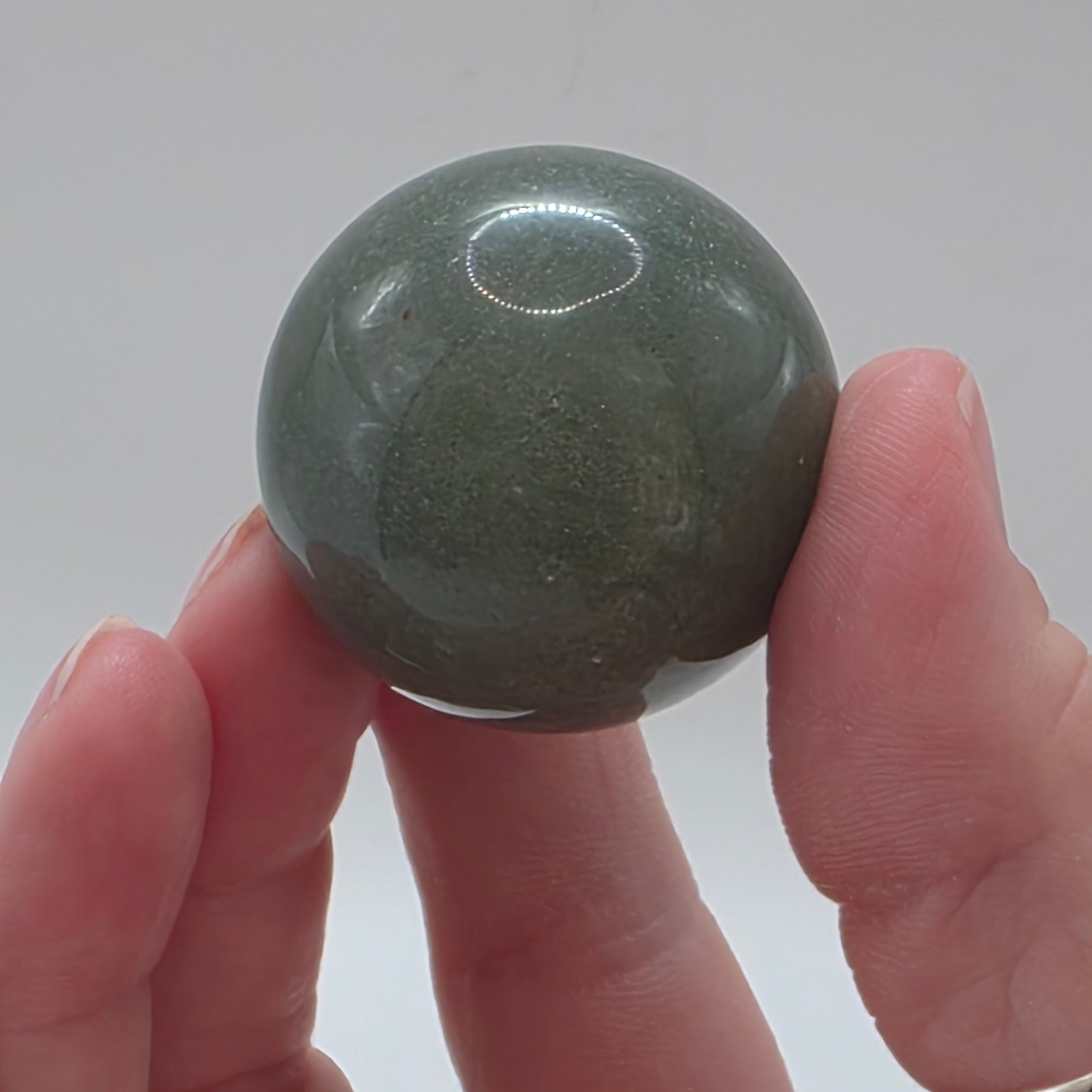 Close up of green aventurine sphere showing natural shimmer and sparkle – aventurescence