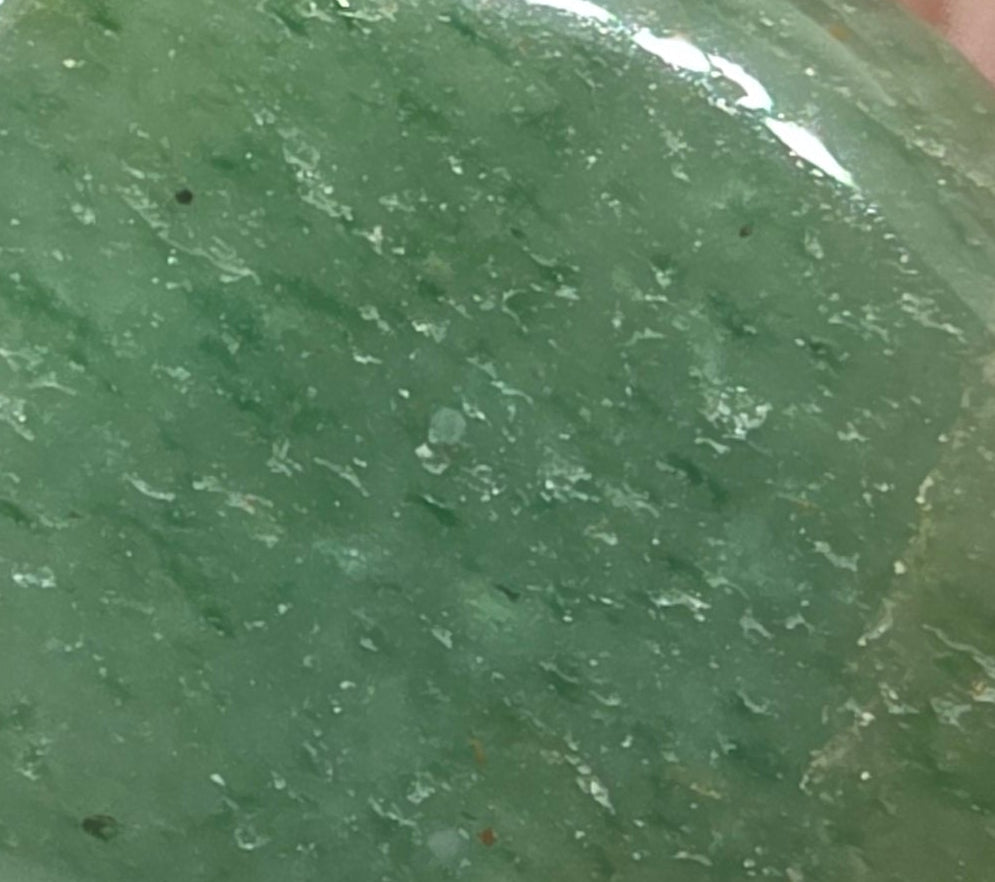 Close up of Green aventurine tumbled stone – dark green crystal for luck and opportunity