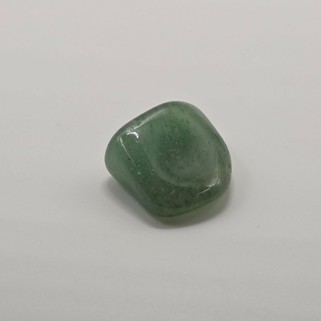 Green aventurine tumbled stone on white background – dark green crystal for luck and opportunity