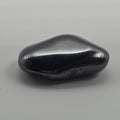Hematite tumbled stone on white background – metallic grey-black crystal for grounding, focus and protection