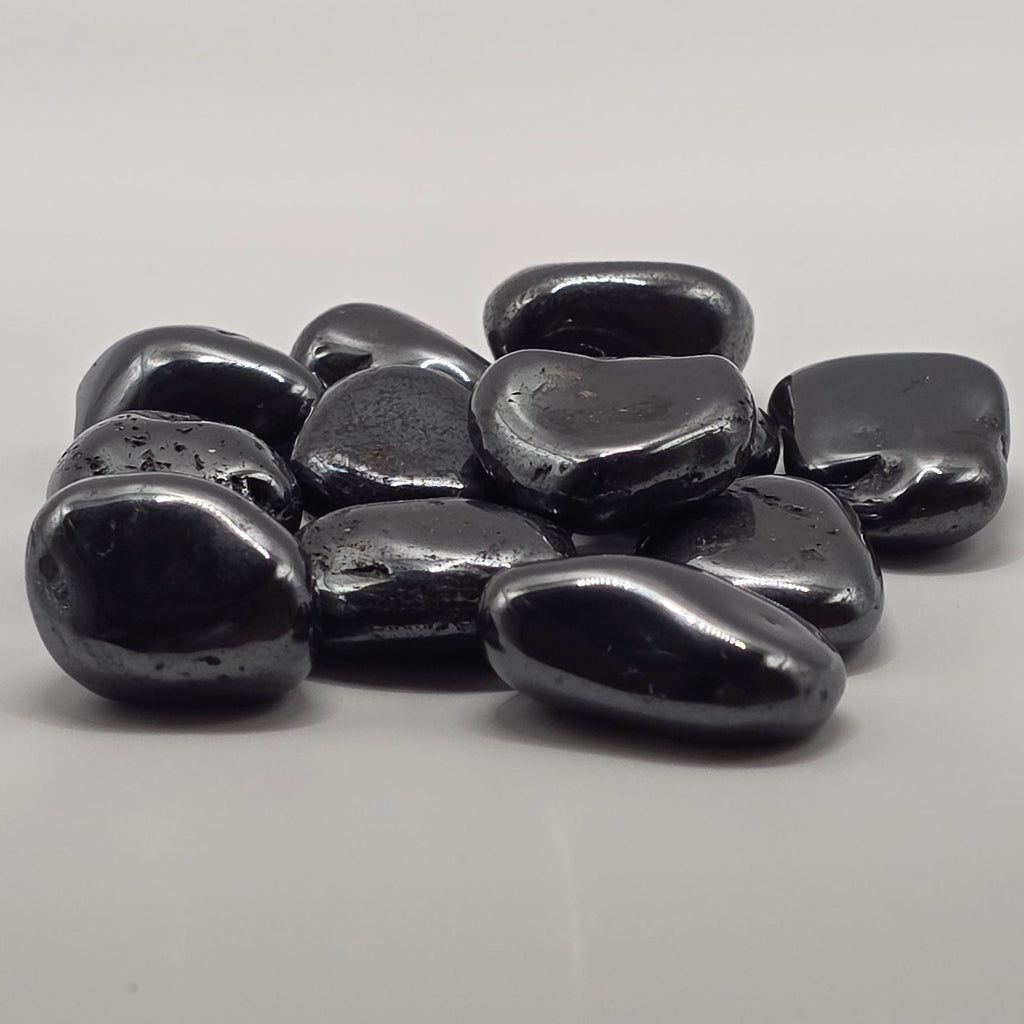 Group of hematite tumbled stones showing natural variation in size, shape and metallic sheen