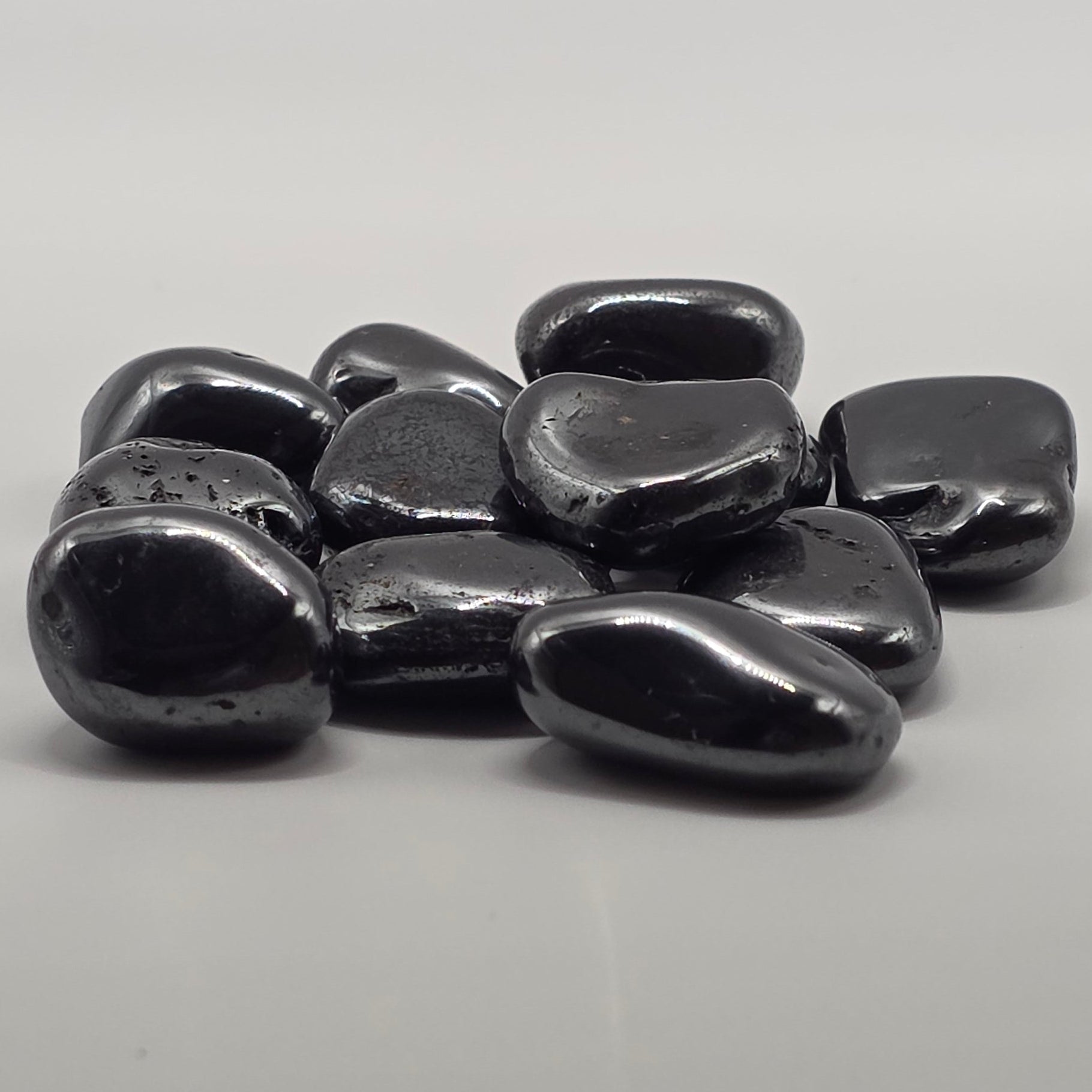 Group of hematite tumbled stones showing natural variation in size, shape and metallic sheen