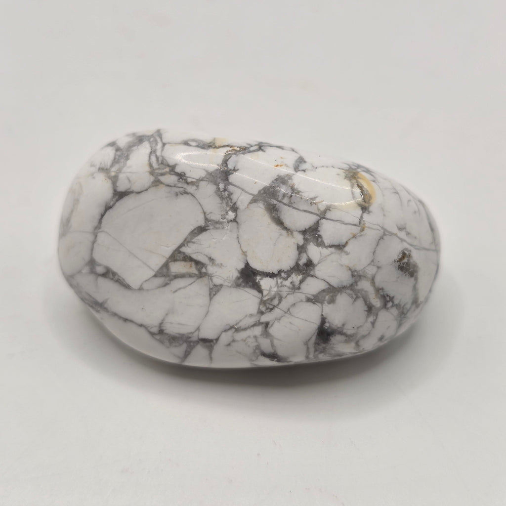 Howlite tumbled stone from South Africa on white background – natural white crystal with grey veining for calm and patience