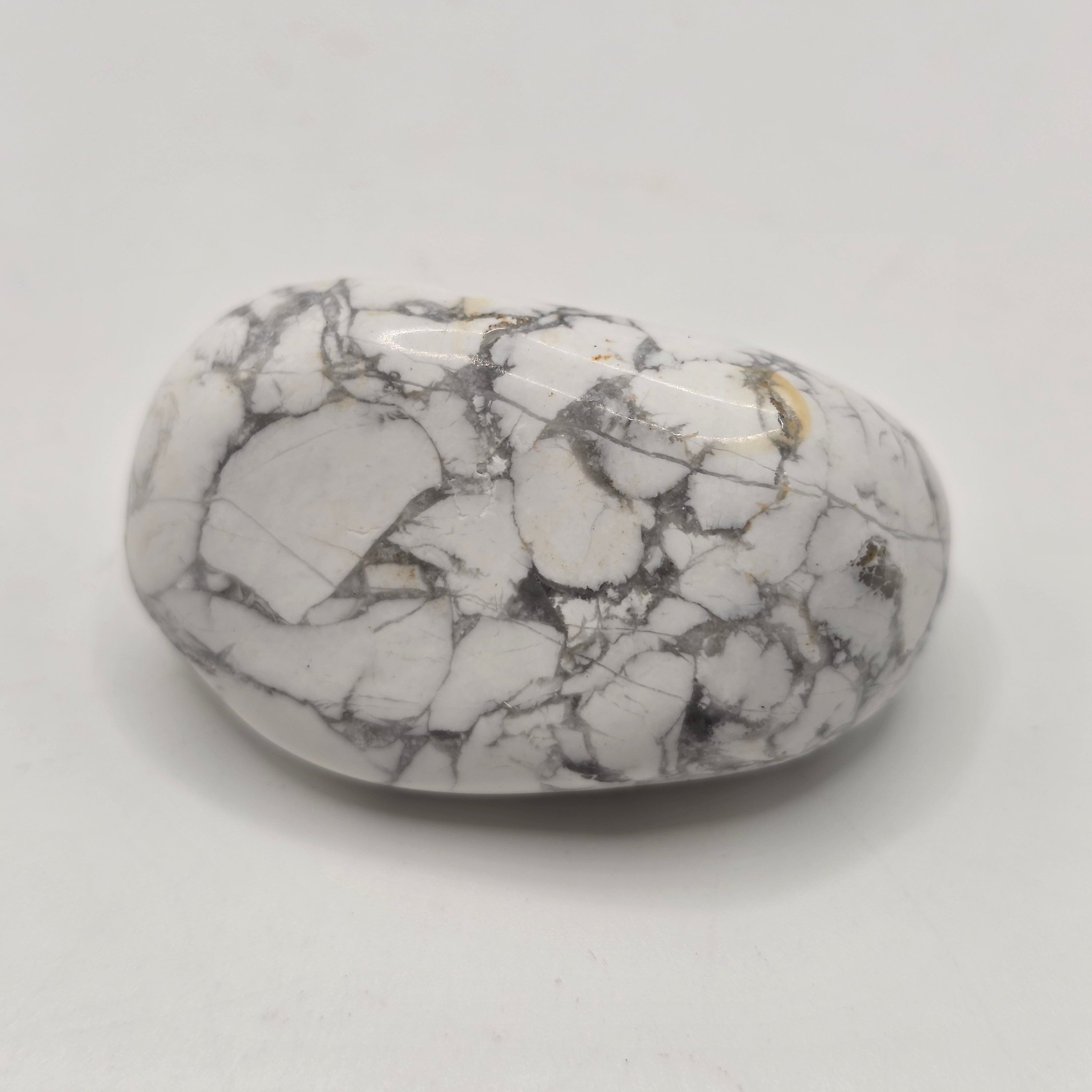 Howlite tumbled stone from South Africa on white background – natural white crystal with grey veining for calm and patience