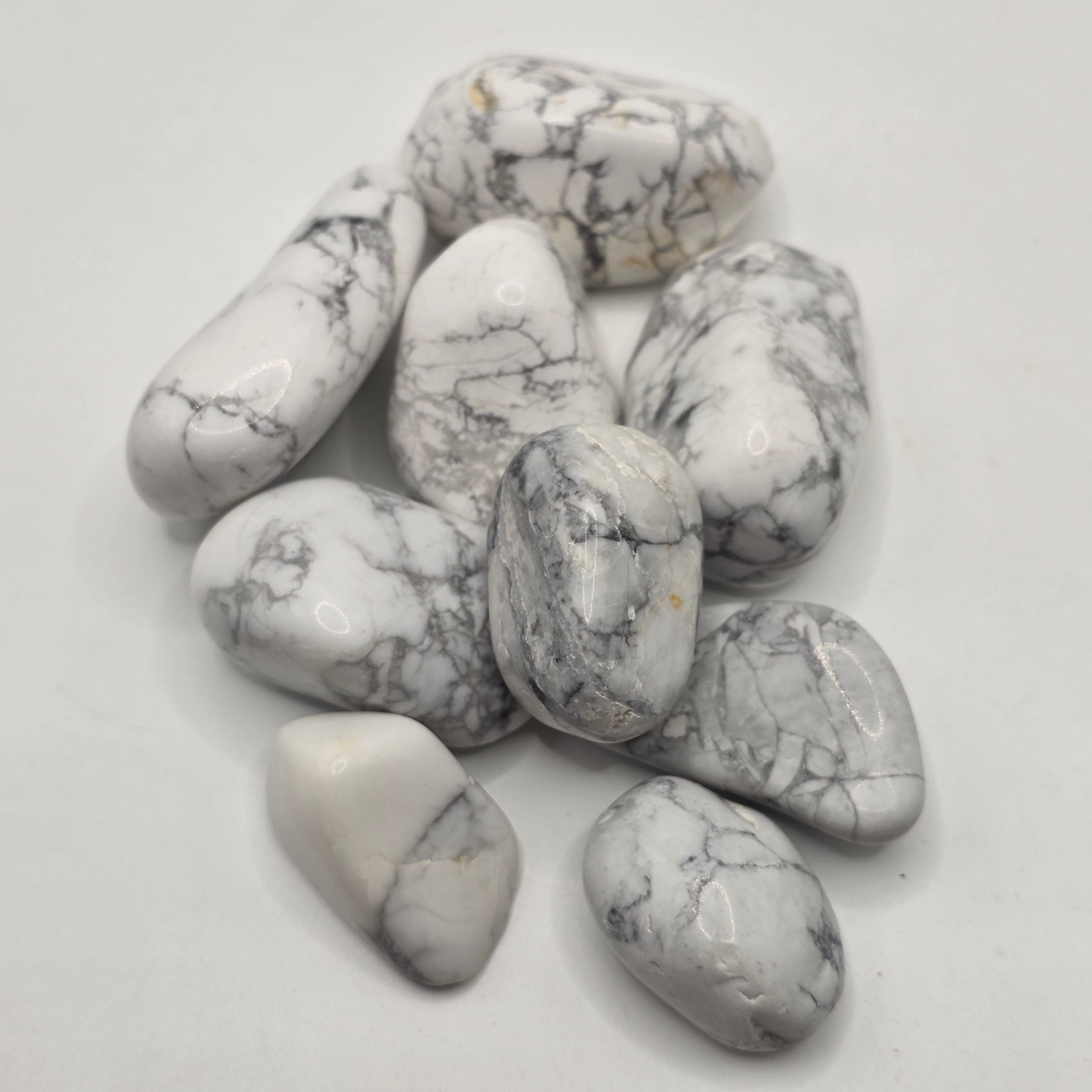 Group of South African howlite tumbled stones showing natural variation in white colour and grey veining patterns