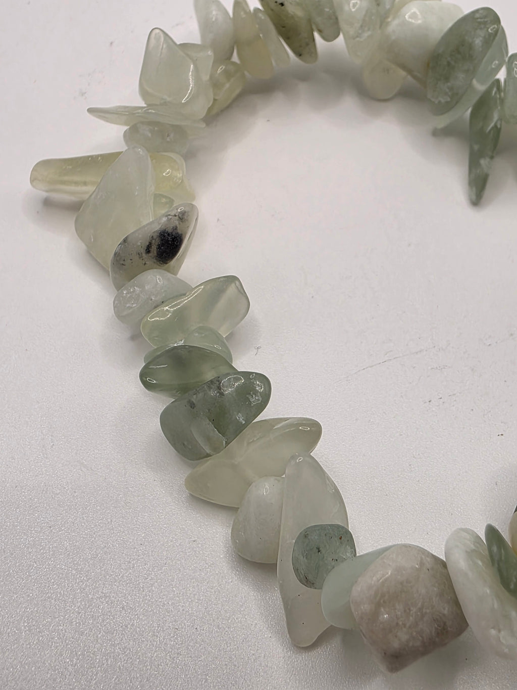 Close up of jade chips showing pale green and creamy natural stone variations