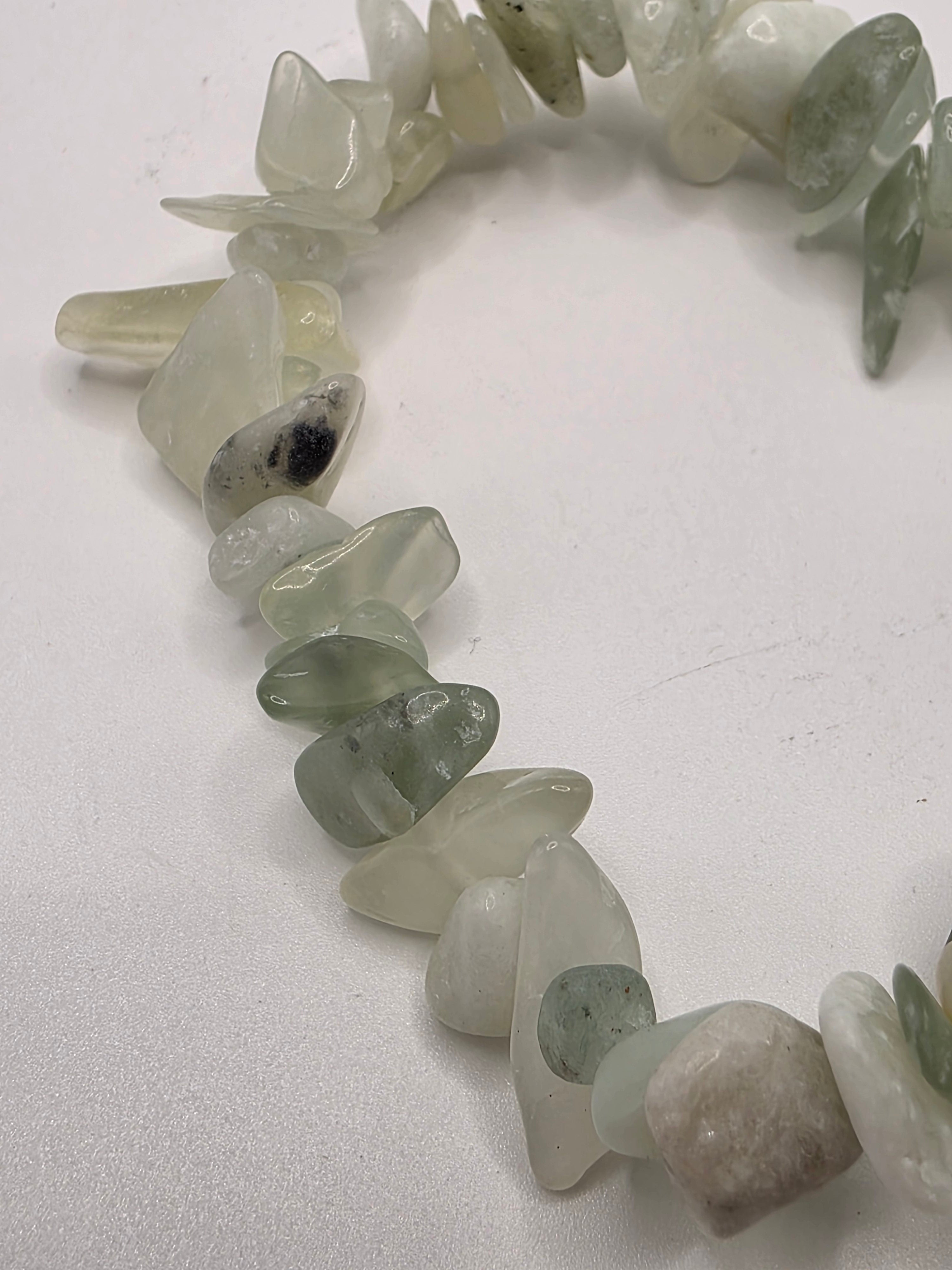Close up of jade chips showing pale green and creamy natural stone variations