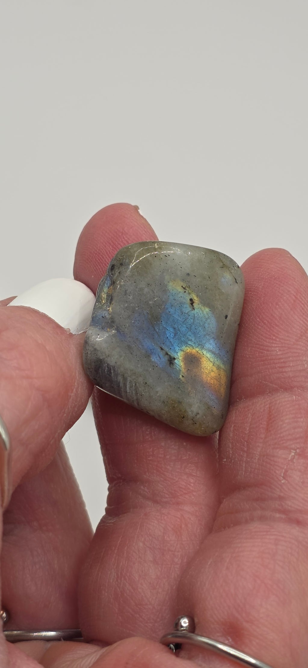 Labradorite tumbled stone between fingers – grey stone with blue-green iridescent flash – 2-3cm polished crystal for transformation