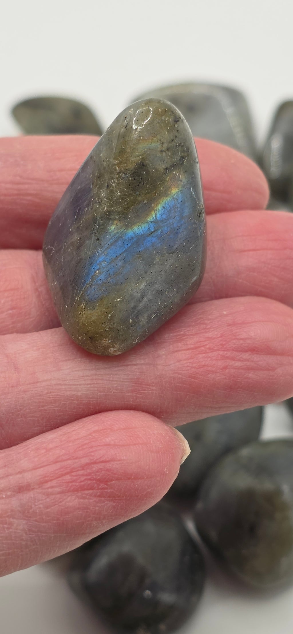 Labradorite tumbled stone in palm – grey stone with blue-green iridescent flash – 2-3cm polished crystal for transformation