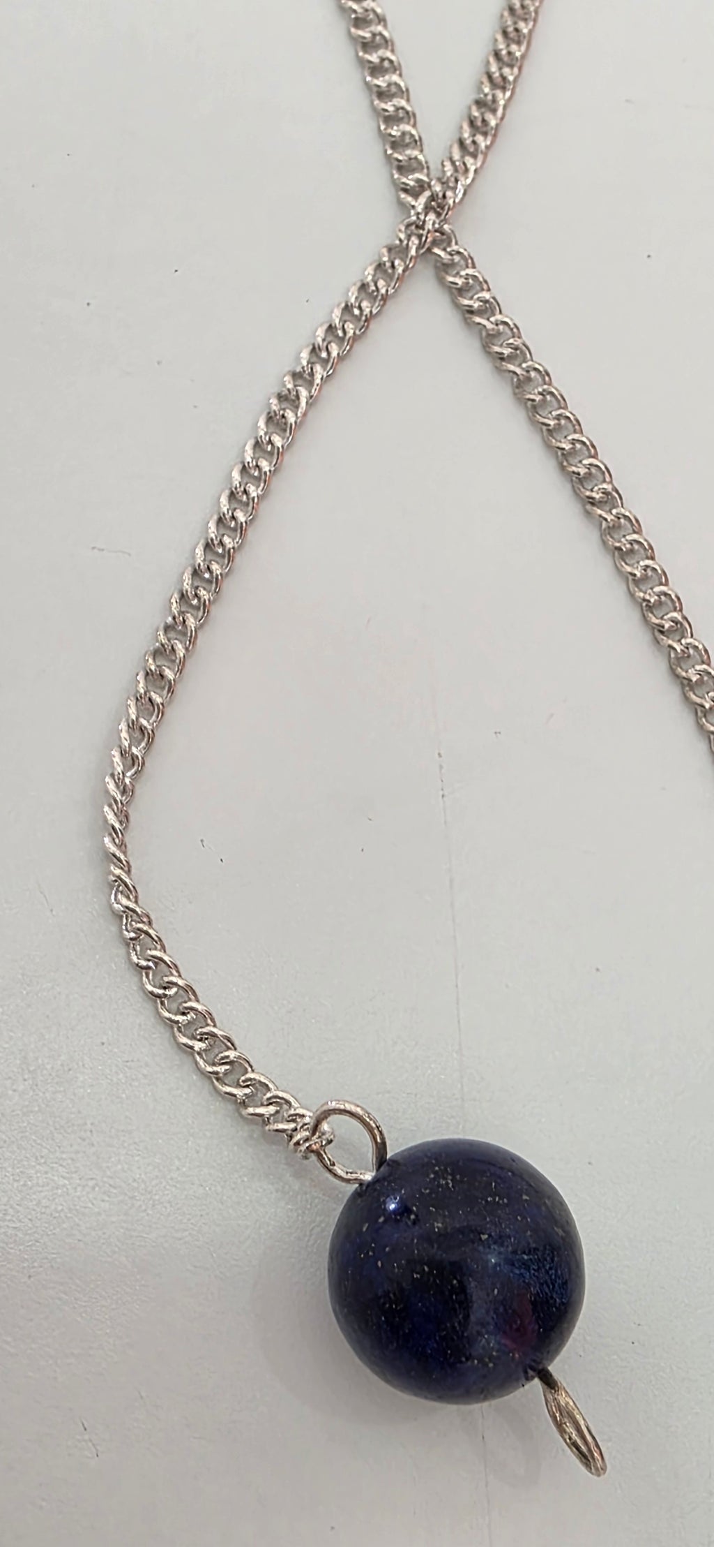 Close up of silver plated pendulum chain and clasp showing metal finish
