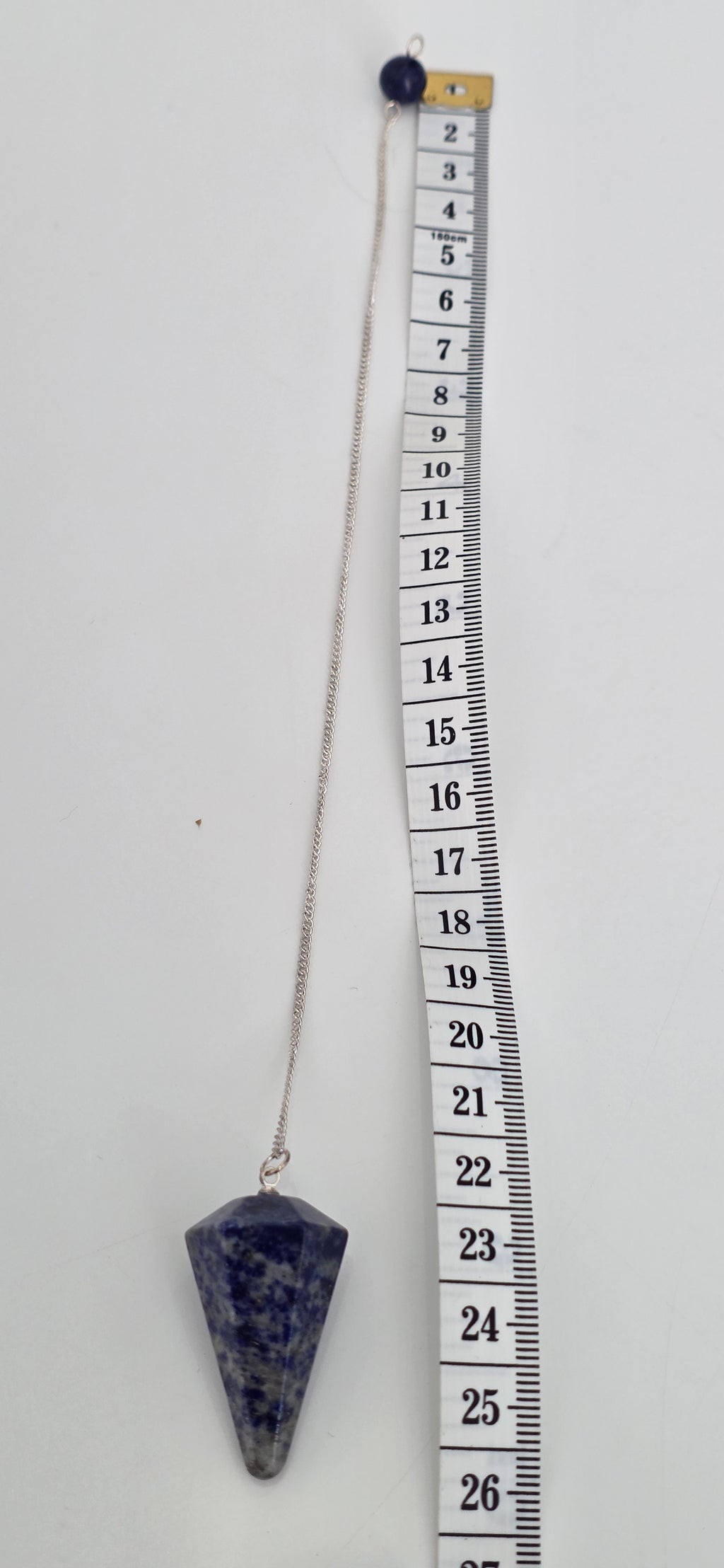 Lapis lazuli pendulum next to a tape measure showing actual size with silver plated chain