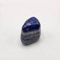 Lapis lazuli tumbled stone on white background – natural deep blue crystal with golden pyrite flecks for wisdom and truth