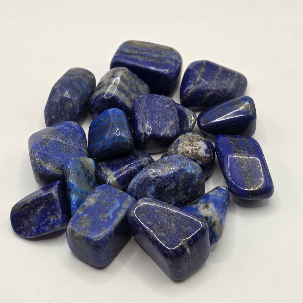 Group of lapis lazuli tumbled stones showing natural variation in blue colour and pyrite distribution
