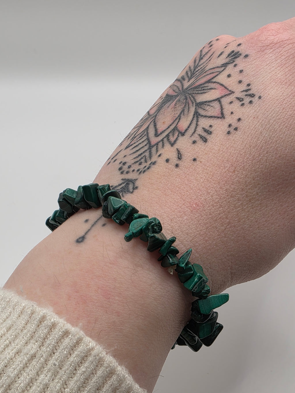 Malachite chip bracelet worn on a wrist – double strung elastic stretch bracelet for crystal healing on the go