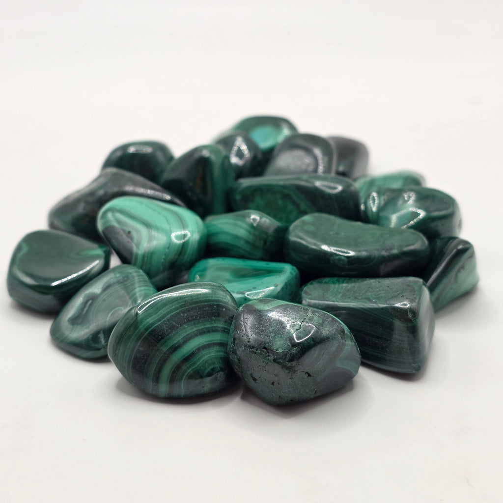 Collection of green malachite stones on a white background