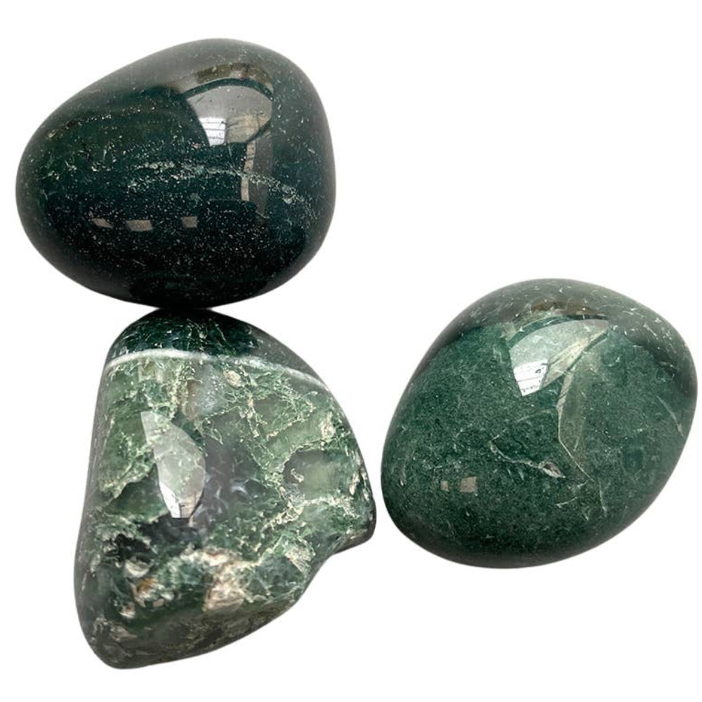 Close up of moss agate tumbled stone showing green moss-like inclusions and natural patterns