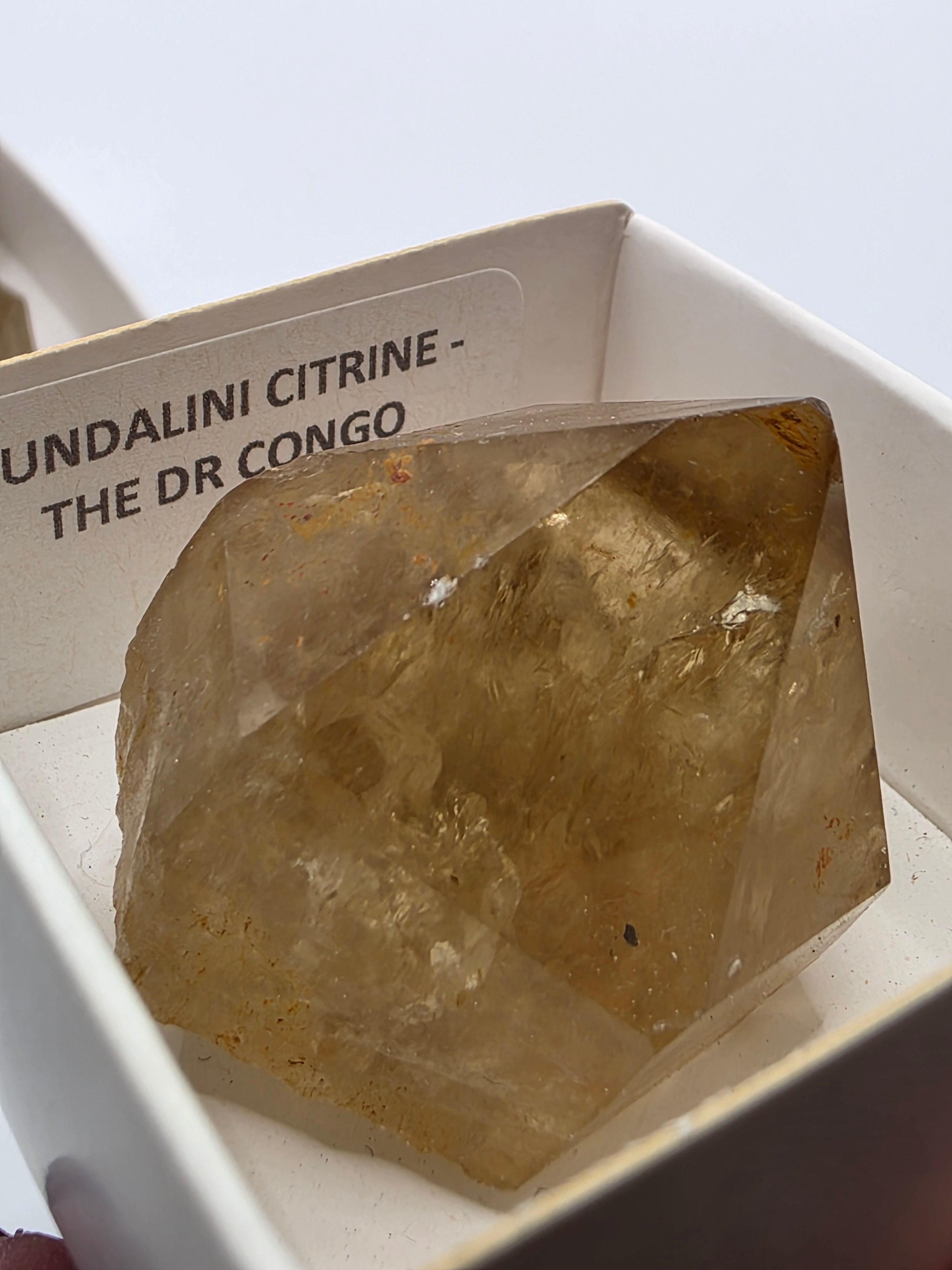 Close up of natural citrine point termination showing raw crystal face and golden colour