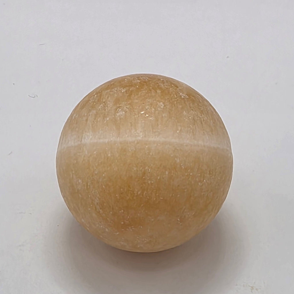 Orange calcite crystal sphere 35mm on white background – natural matte finish stone for creativity and vitality
