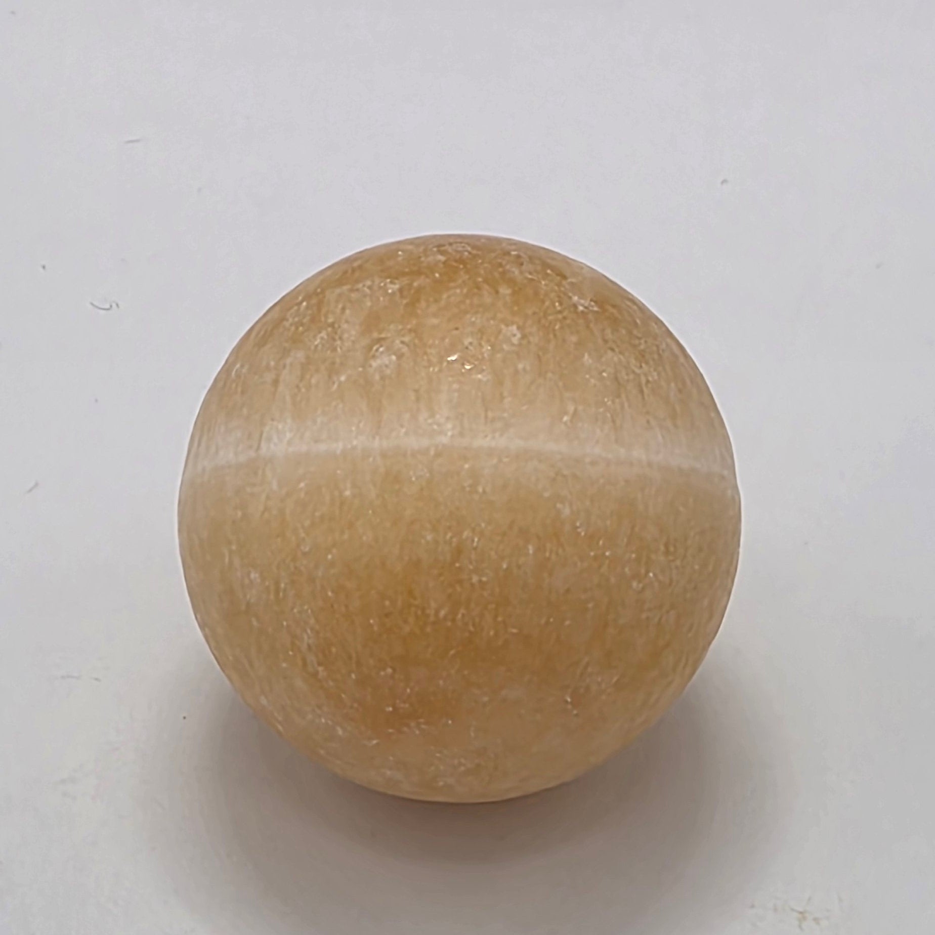 Orange calcite crystal sphere 35mm on white background – natural matte finish stone for creativity and vitality